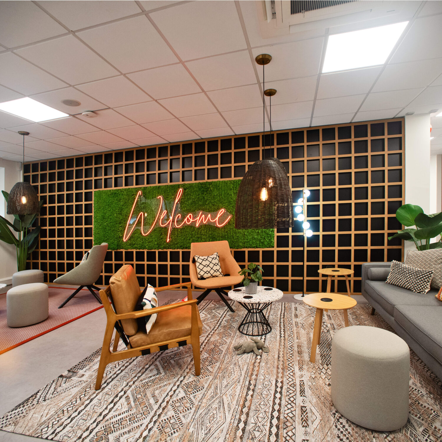 seating area with sofas and chairs by welcome sign on wall