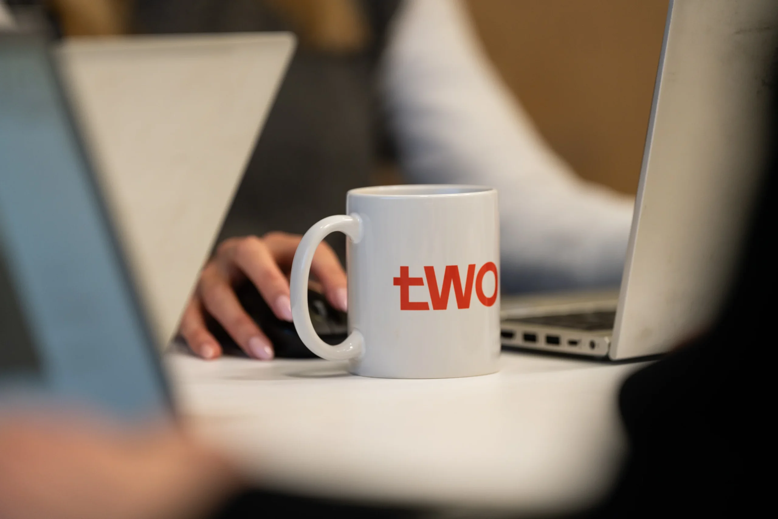 Two meeting with laptops and Two branded mugs