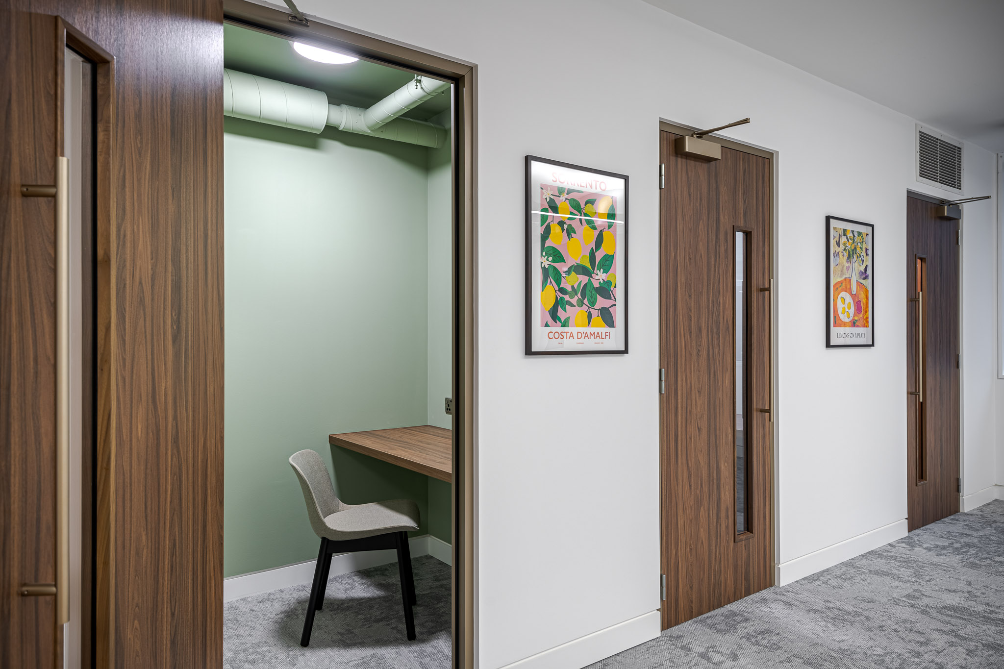 Asset Management phone booth with brown oak doors, and a light green paint on the inside of the room.