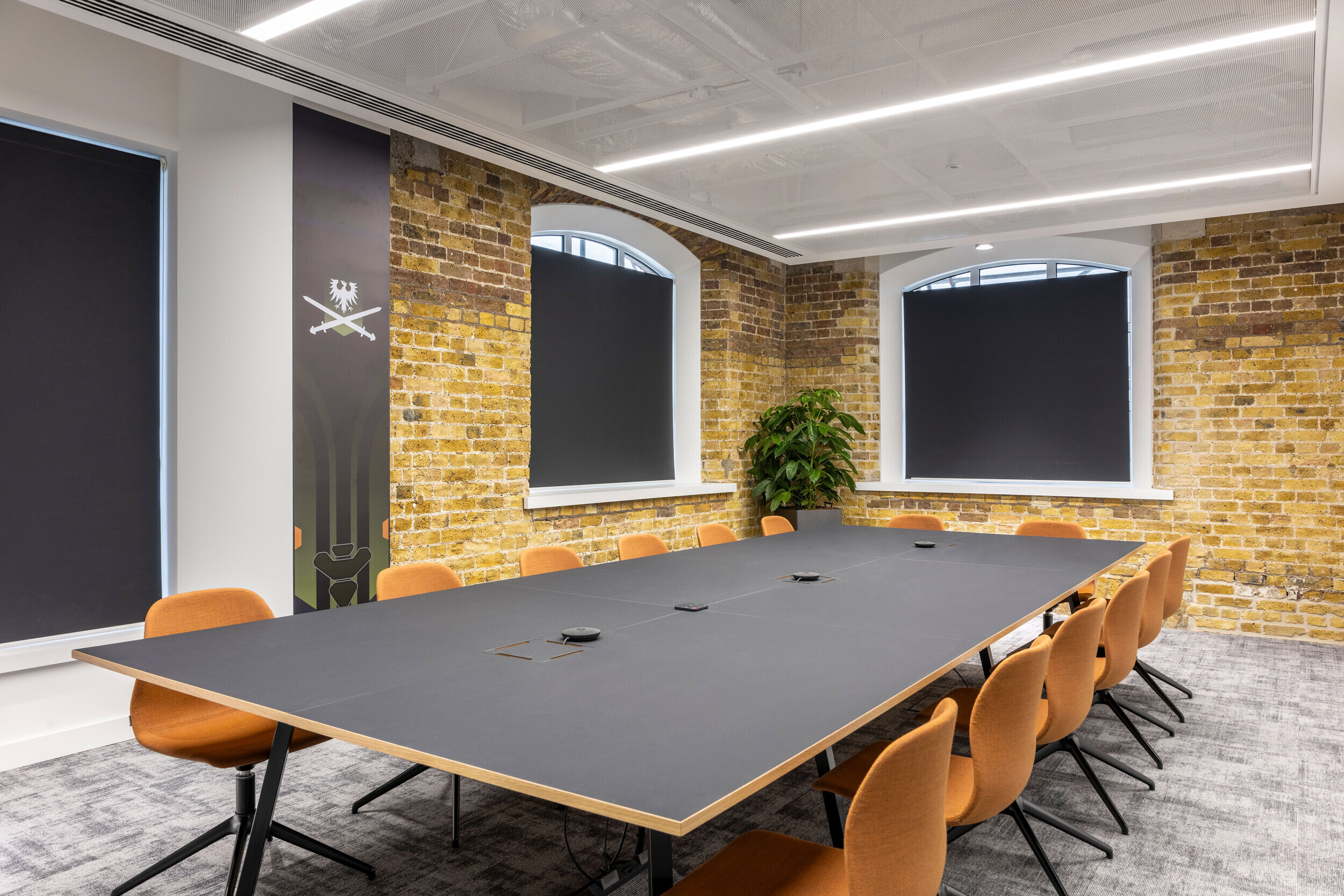 Industrial-style boardroom at CCP Games’s office, featuring exposed brick walls, orange chairs, and a large central table.