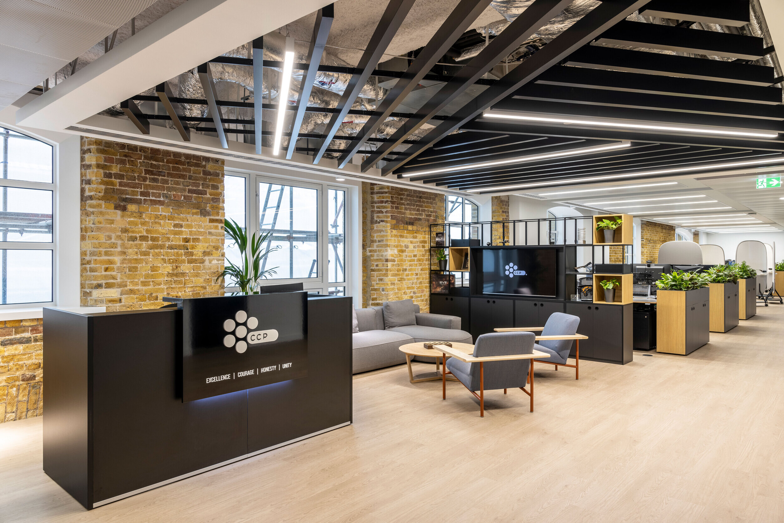 CCP Games' welcoming reception area, designed by Two, combines industrial brickwork, sleek black furniture, exposed ceilings and greenery for a modern aesthetic.