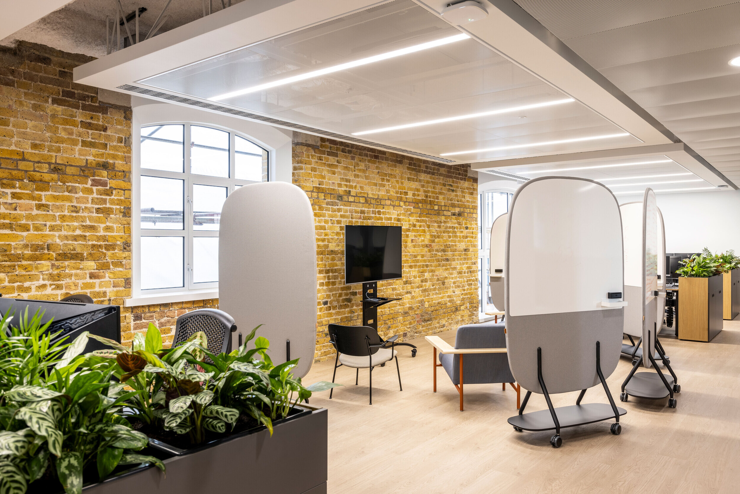 Innovative office layout with mobile whiteboards, breakout seating, and industrial finishes at CCP Games, promoting agile working.