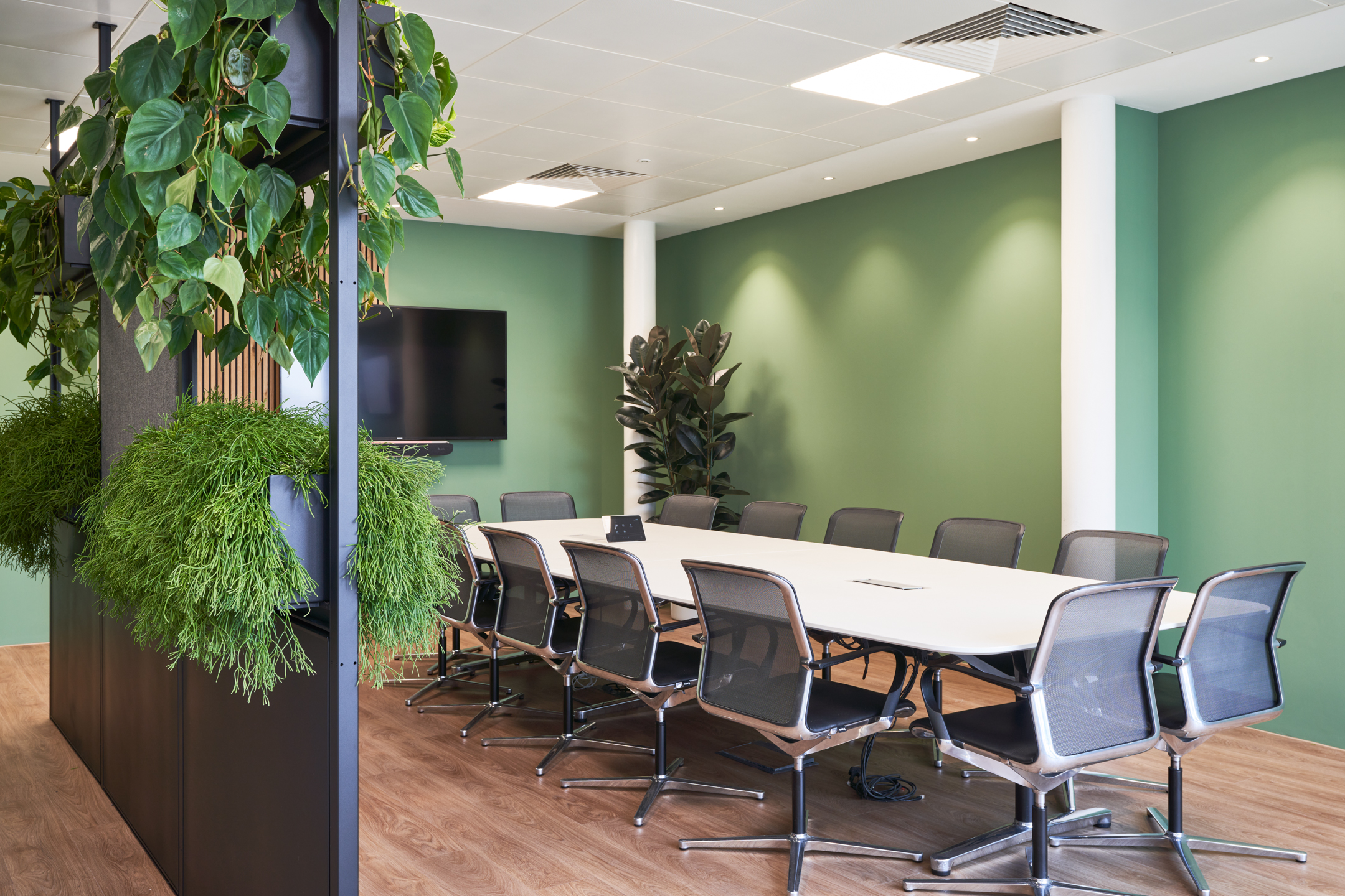 Spacious meeting room in the KPI Ocean Connect office, designed by Two, with ergonomic chairs, natural greenery, and a modern conference setup.