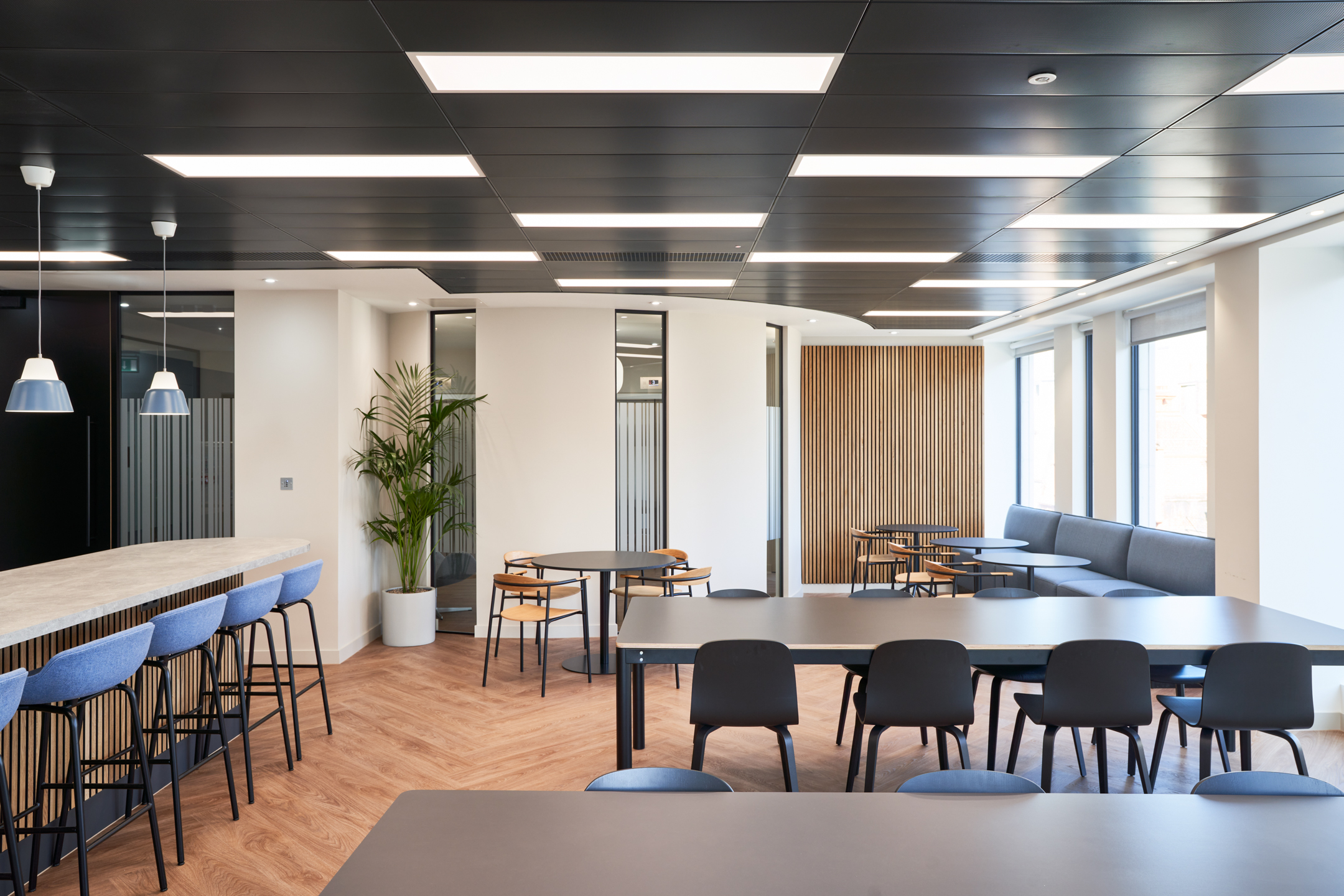 Collaborative office space by Two for KPI Ocean Connect, featuring open seating, large tables, and city views.