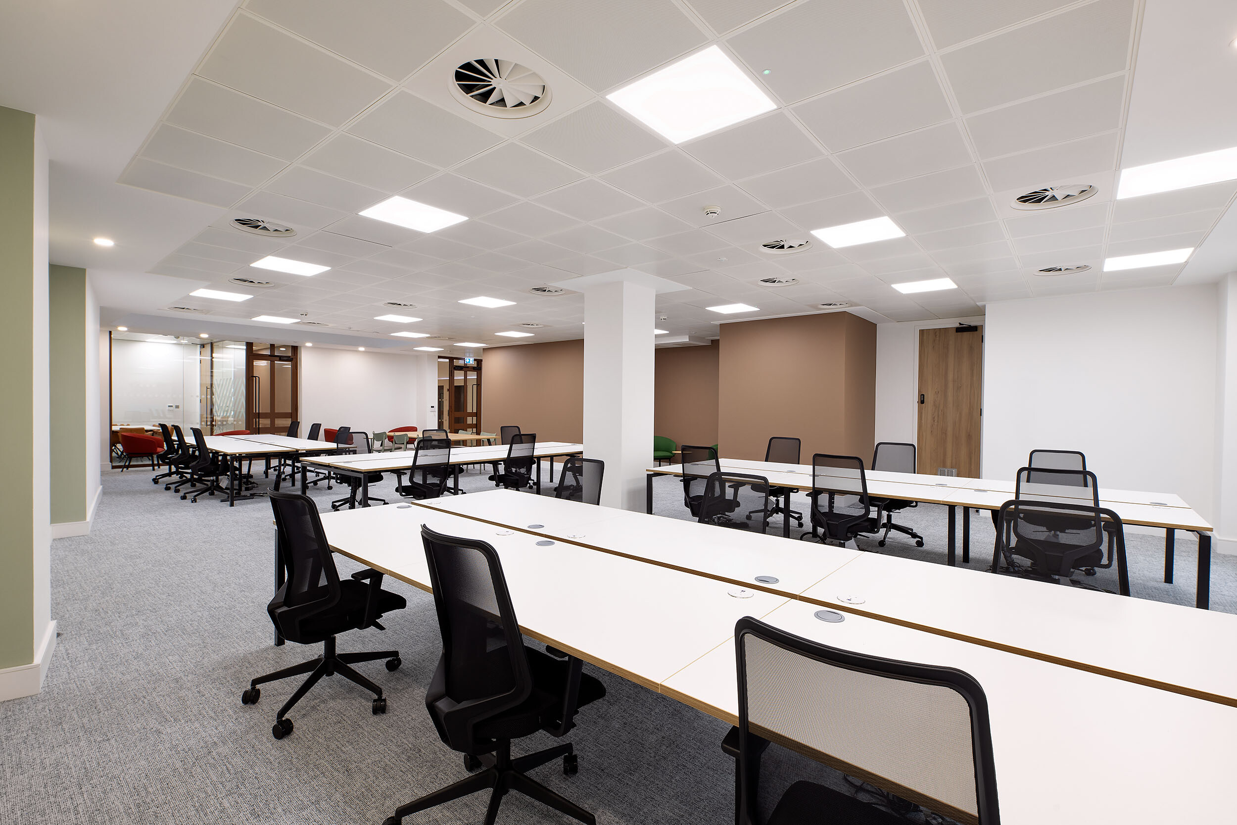 An expansive open-plan office at 123 Pall Mall, designed by Two, featuring rows of white desks, ergonomic chairs, and a layout optimised for team collaboration.