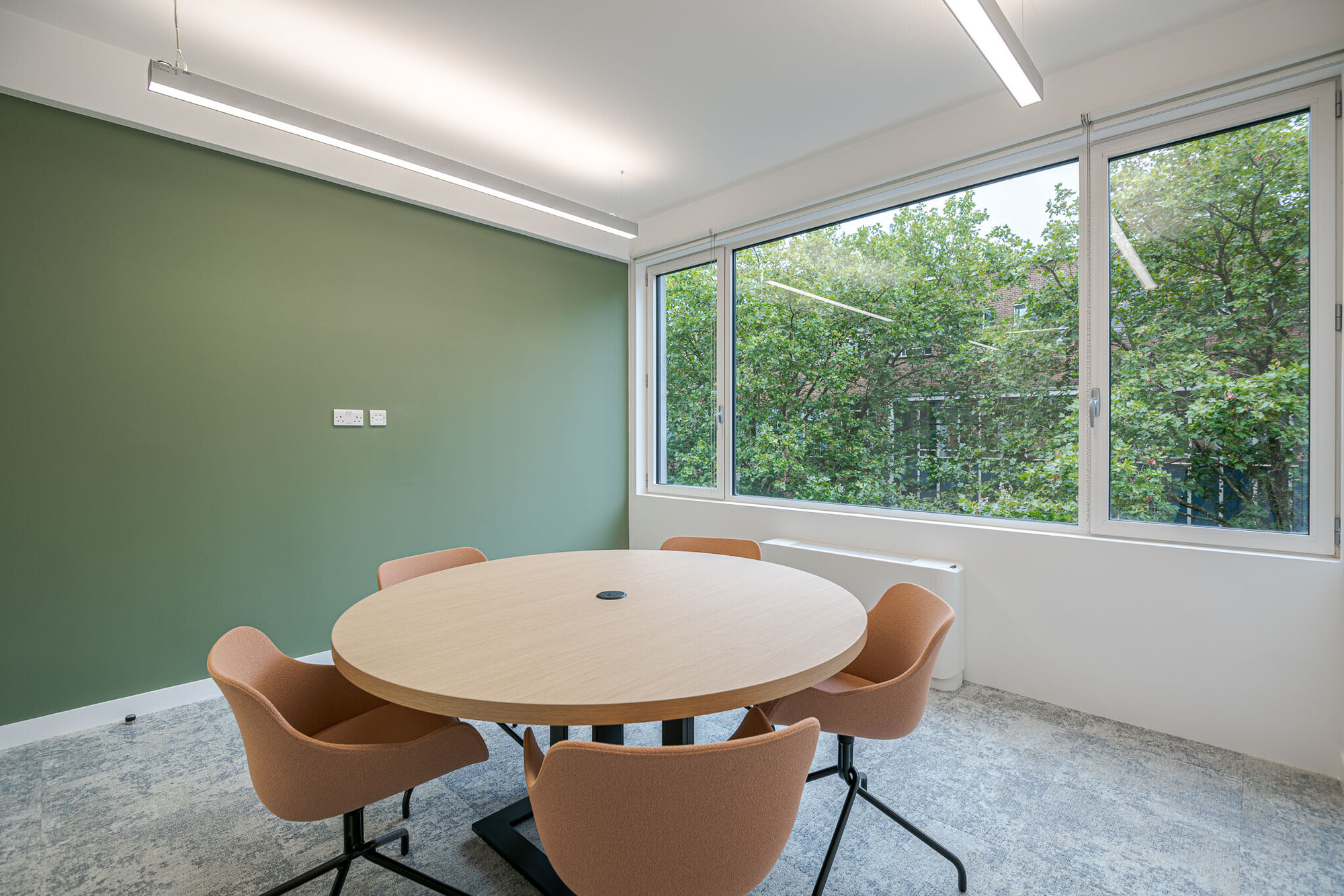 Elegant Berry Street office workspace designed by Two, featuring round meeting tables and vibrant plant decorations.