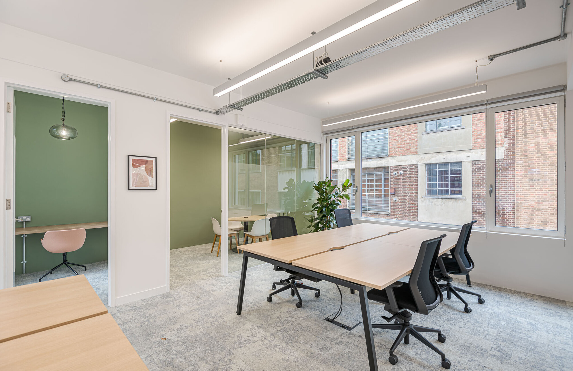 Minimalist office breakout space on Berry Street designed by Two, with sleek chairs and a view of the green outdoors.