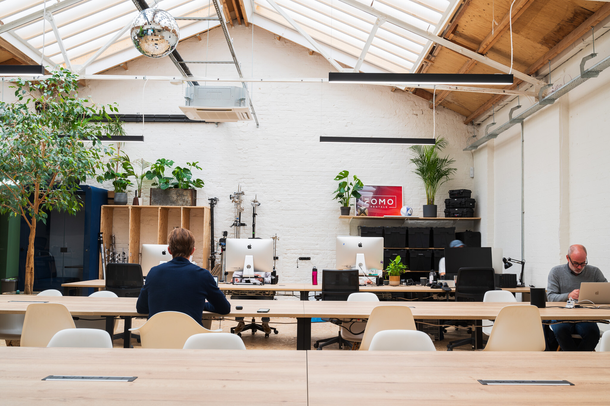 Modern office space for FOMO Rentals designed by Two, with skylights that fill the room with natural light and a variety of collaborative areas.