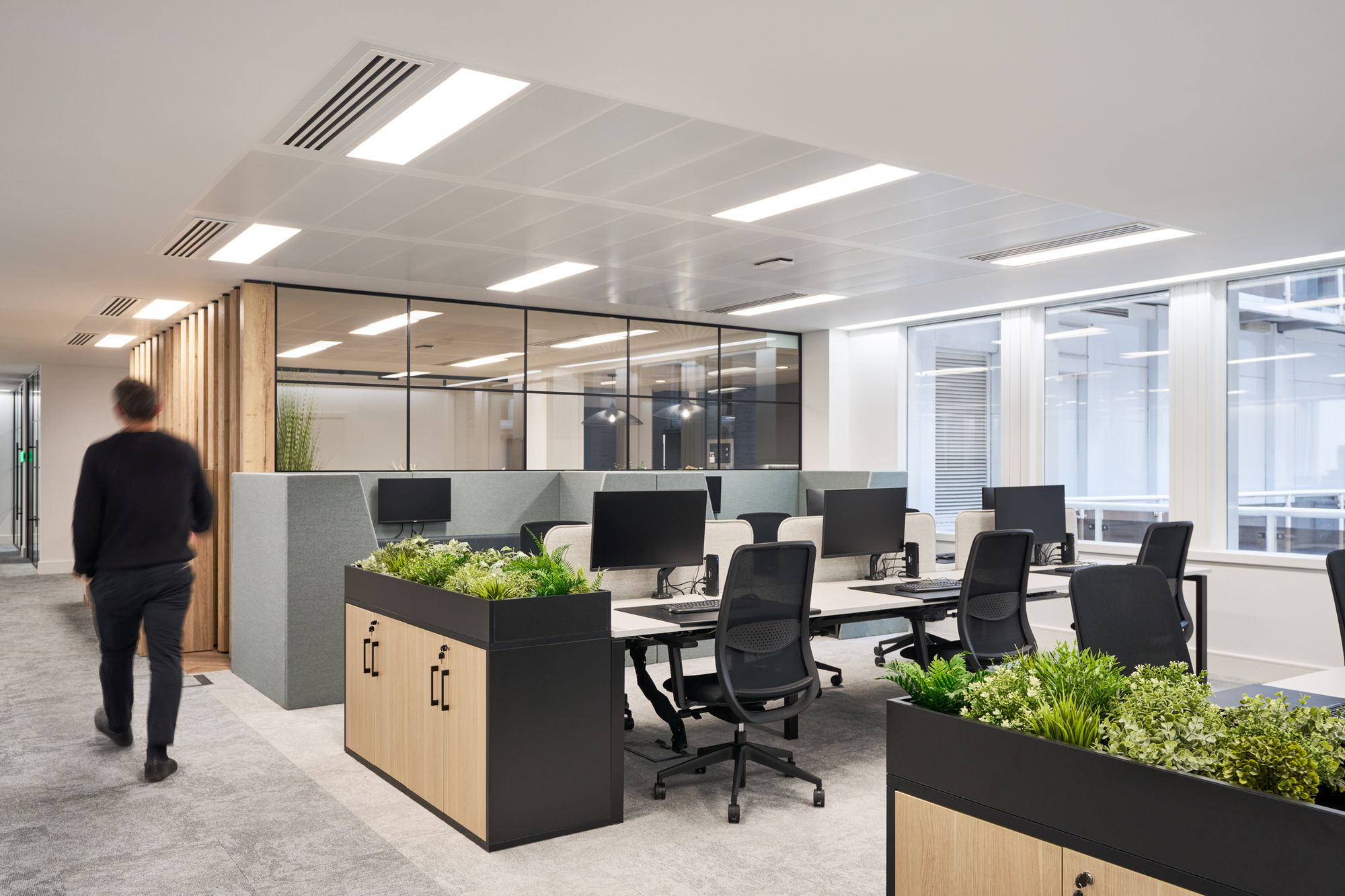 Gemserv's open-plan workspace designed by Two, featuring ergonomic desks, acoustic dividers, and greenery for a balanced and productive environment.