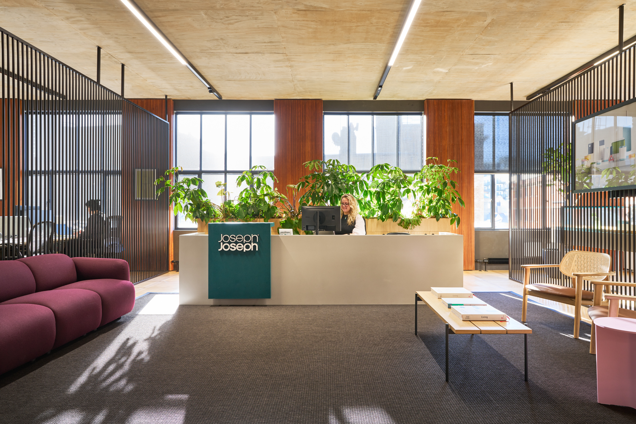 Reception area of the Joseph Joseph office, featuring lush greenery, modern furniture, and a welcome desk.