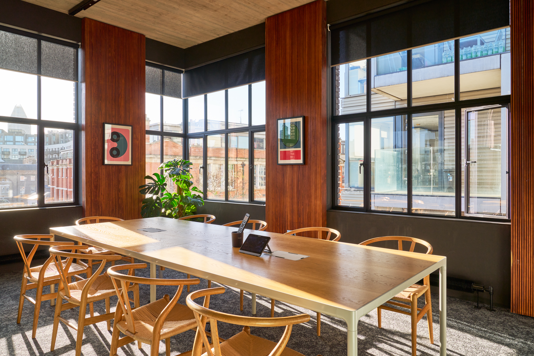 Meeting room in the Joseph Joseph office, designed by Two, showcasing a large wooden table, natural light, and views of the surrounding cityscape.