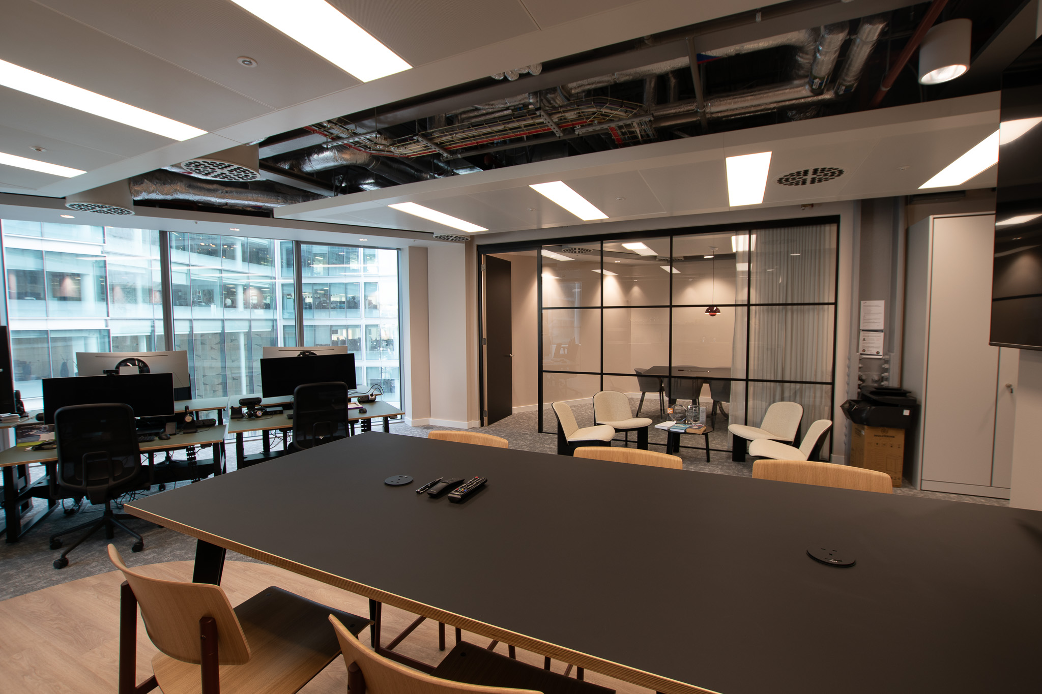 Sophisticated office design at Landsec Nova North by Two, featuring a large meeting table with sleek chairs and exposed ceiling.