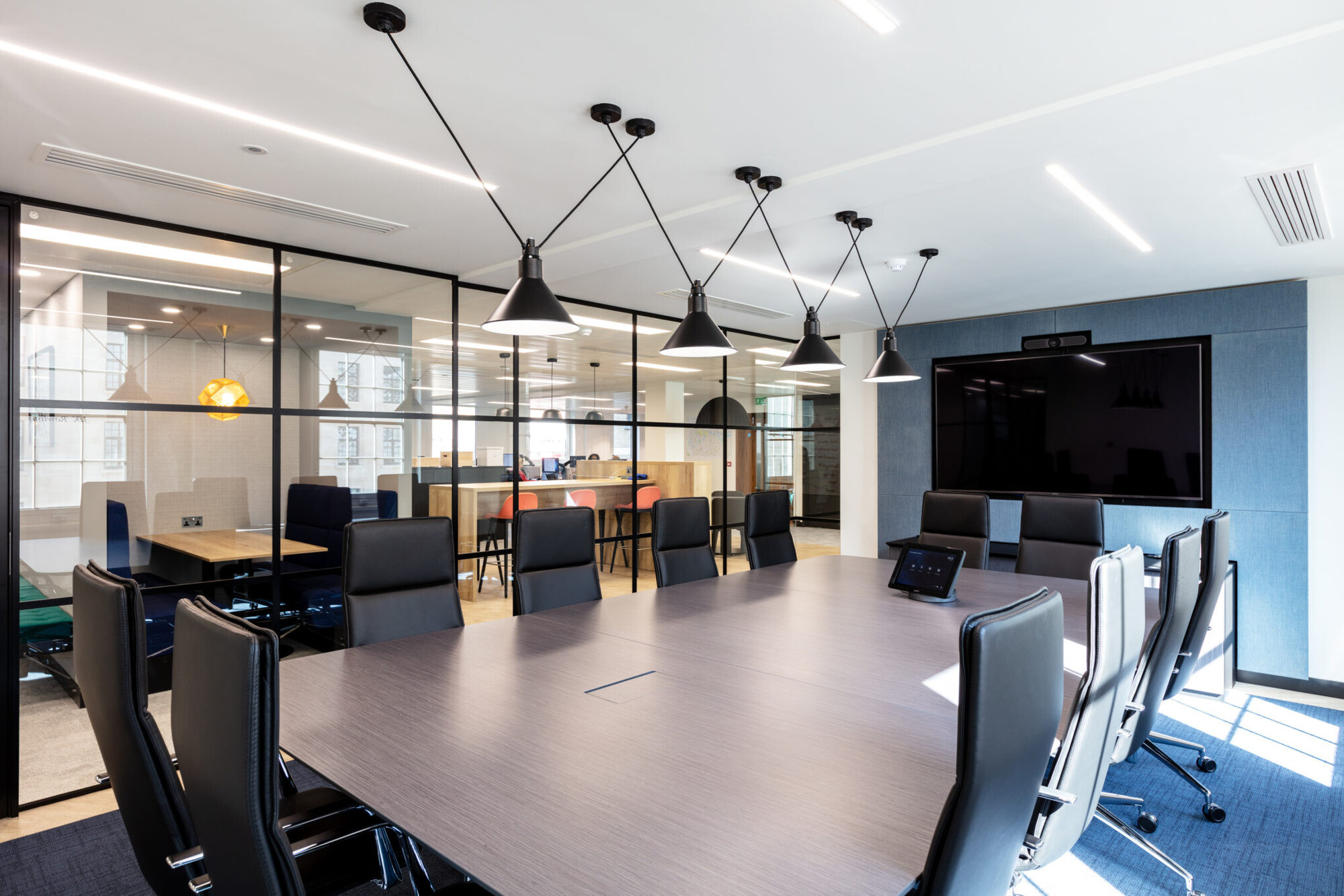 The meeting room’s layout, providing a functional space for meetings with modern furnishings and natural light from large windows.