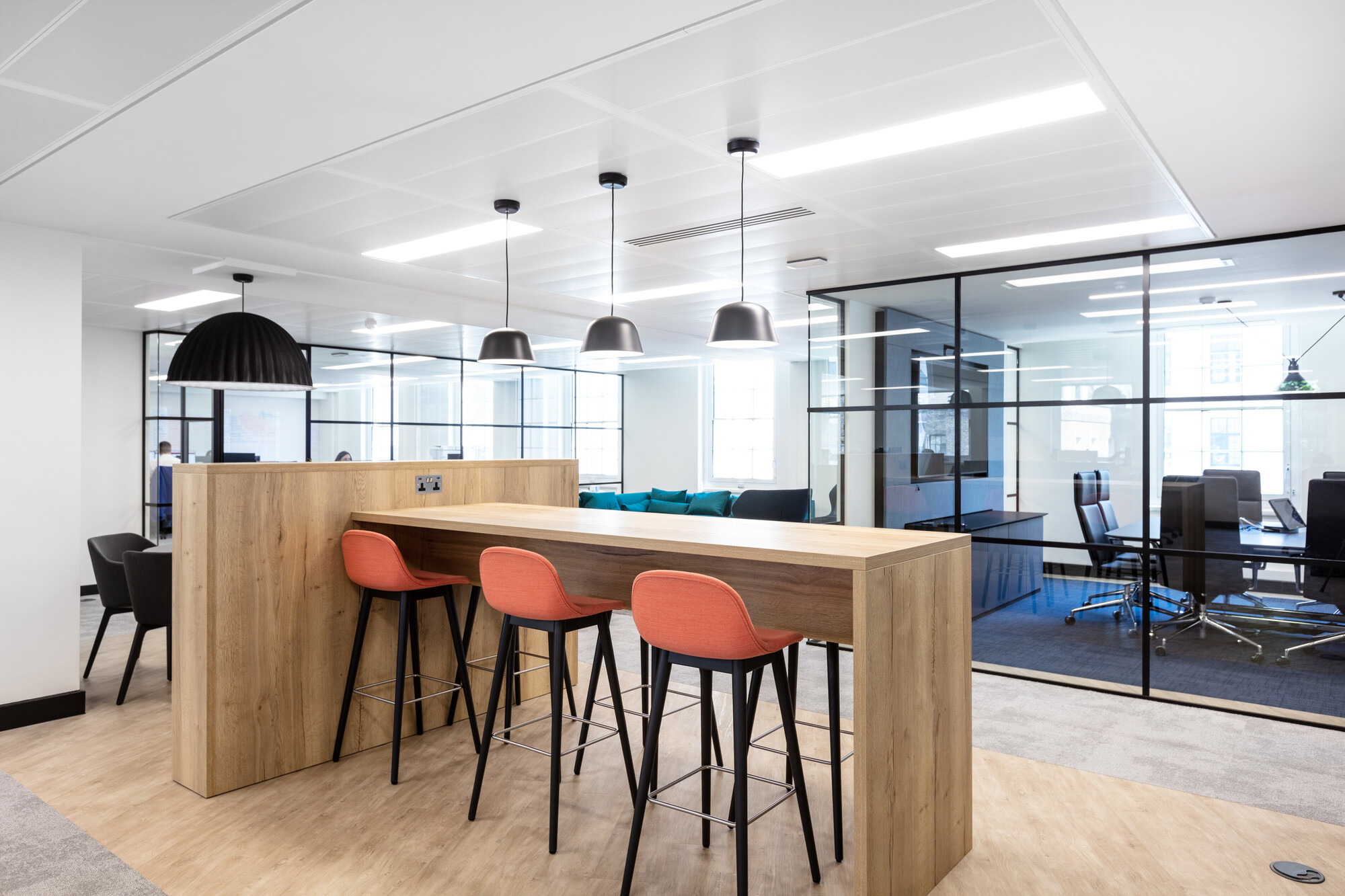 A high table and bar stools in a breakout space for Literacy Capital provide an informal area for quick meetings or social interactions.