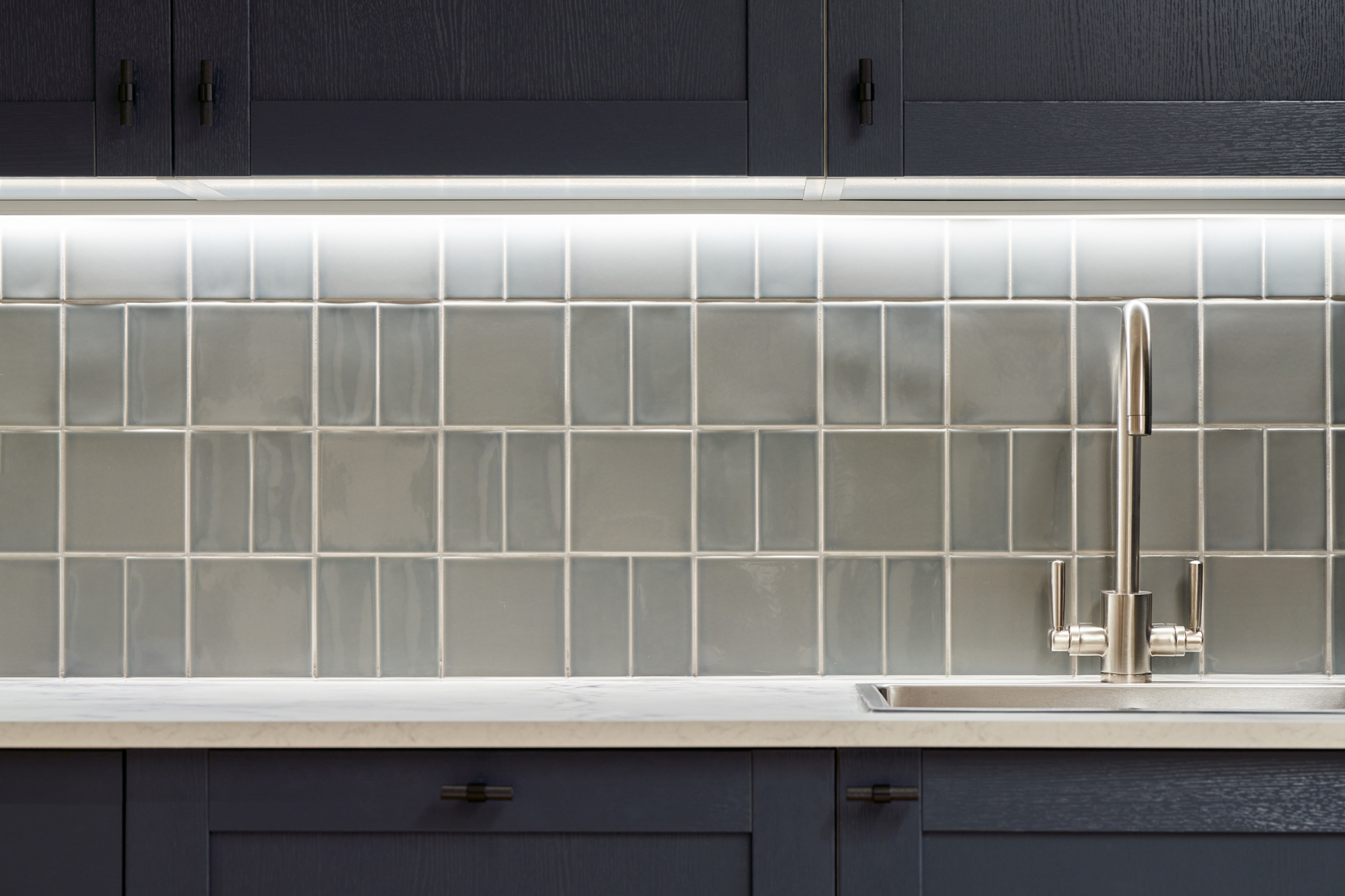 Close-up of the tiled backsplash and sink in the Nolan Partners office kitchen, designed by Two.