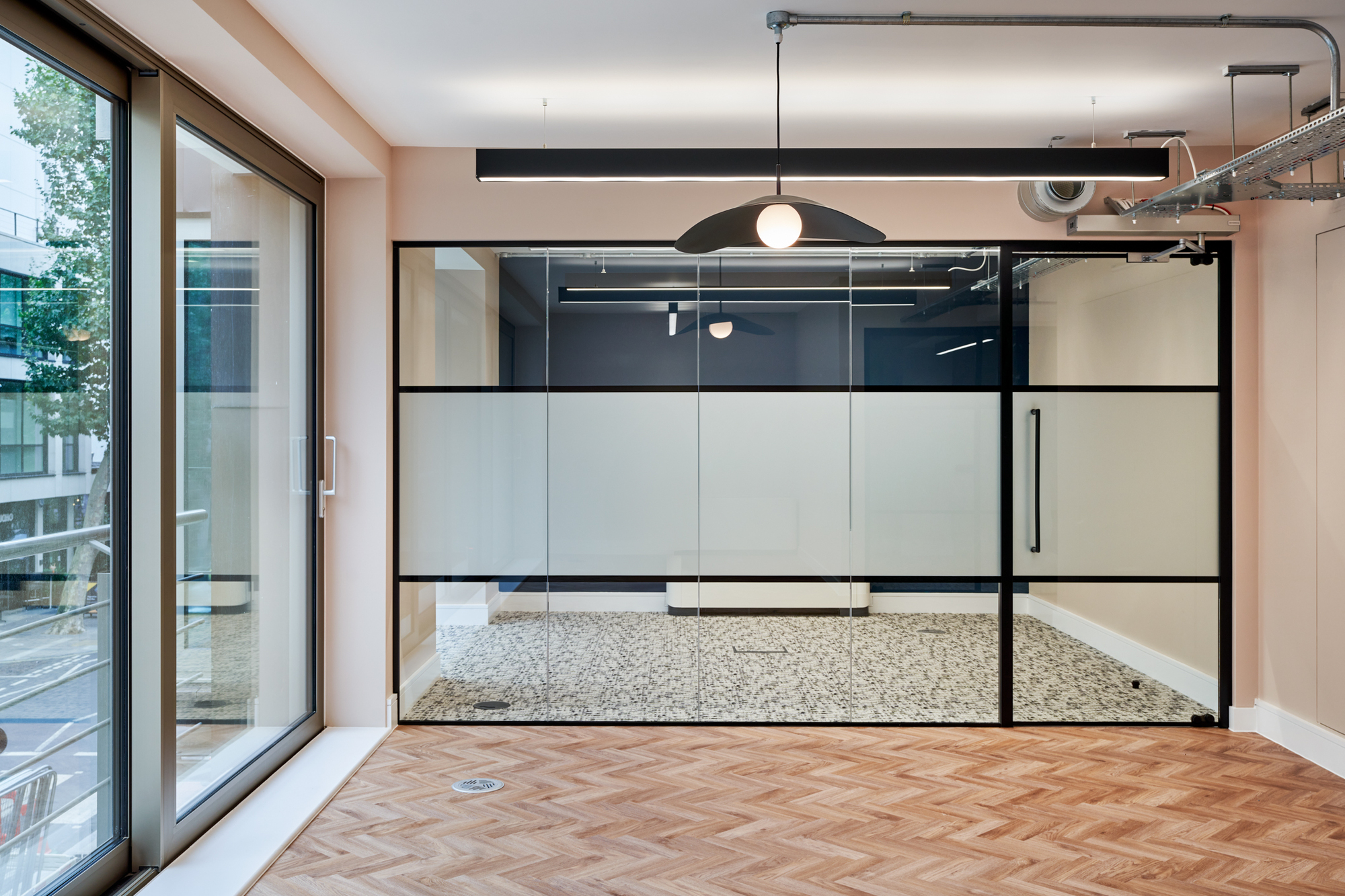 Glazing enclosed meeting room with patterned flooring in the Nolan Partners office.