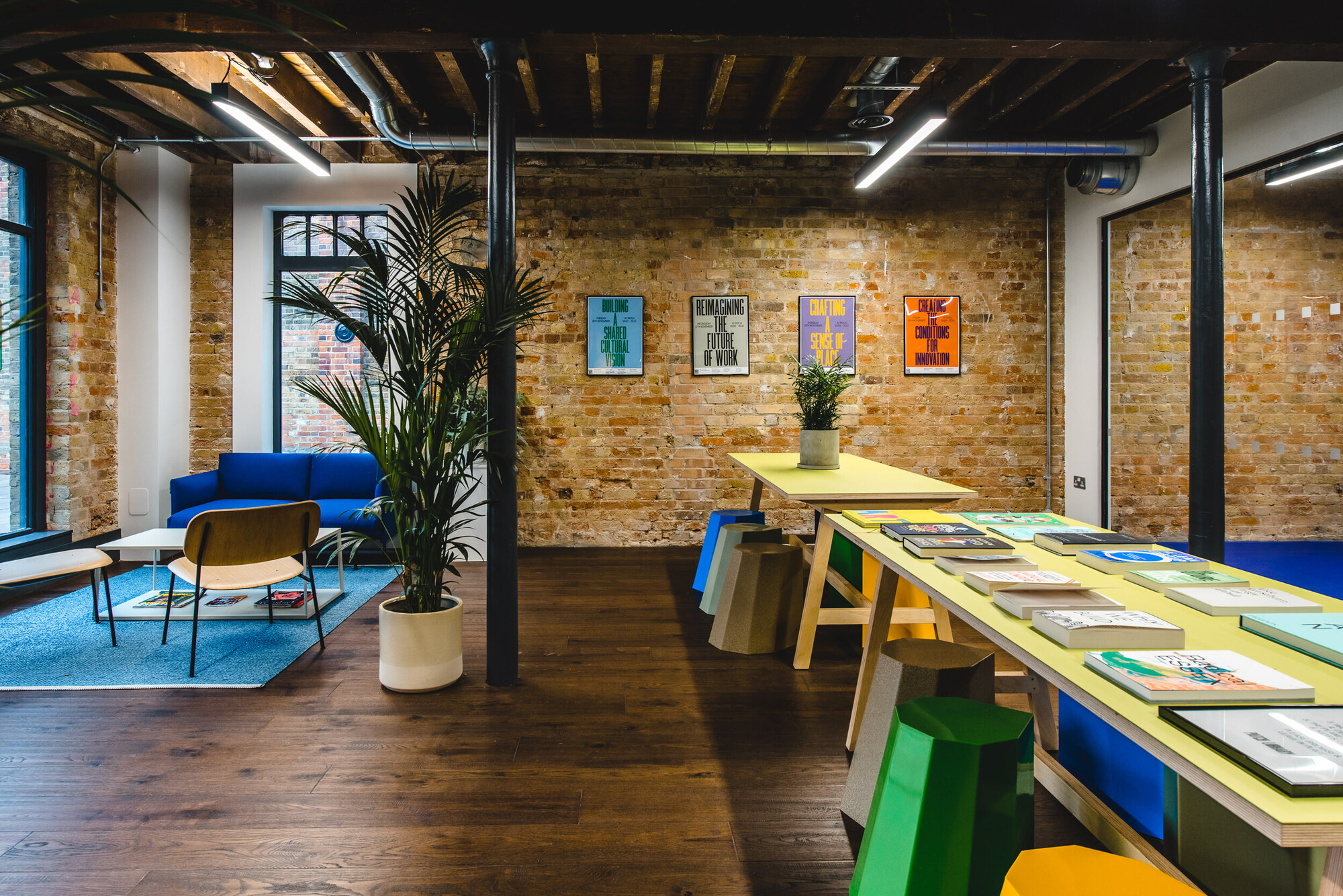 Patch community space designed by Two, featuring exposed brick walls, colourful furniture, and a flexible seating area for collaborative work.