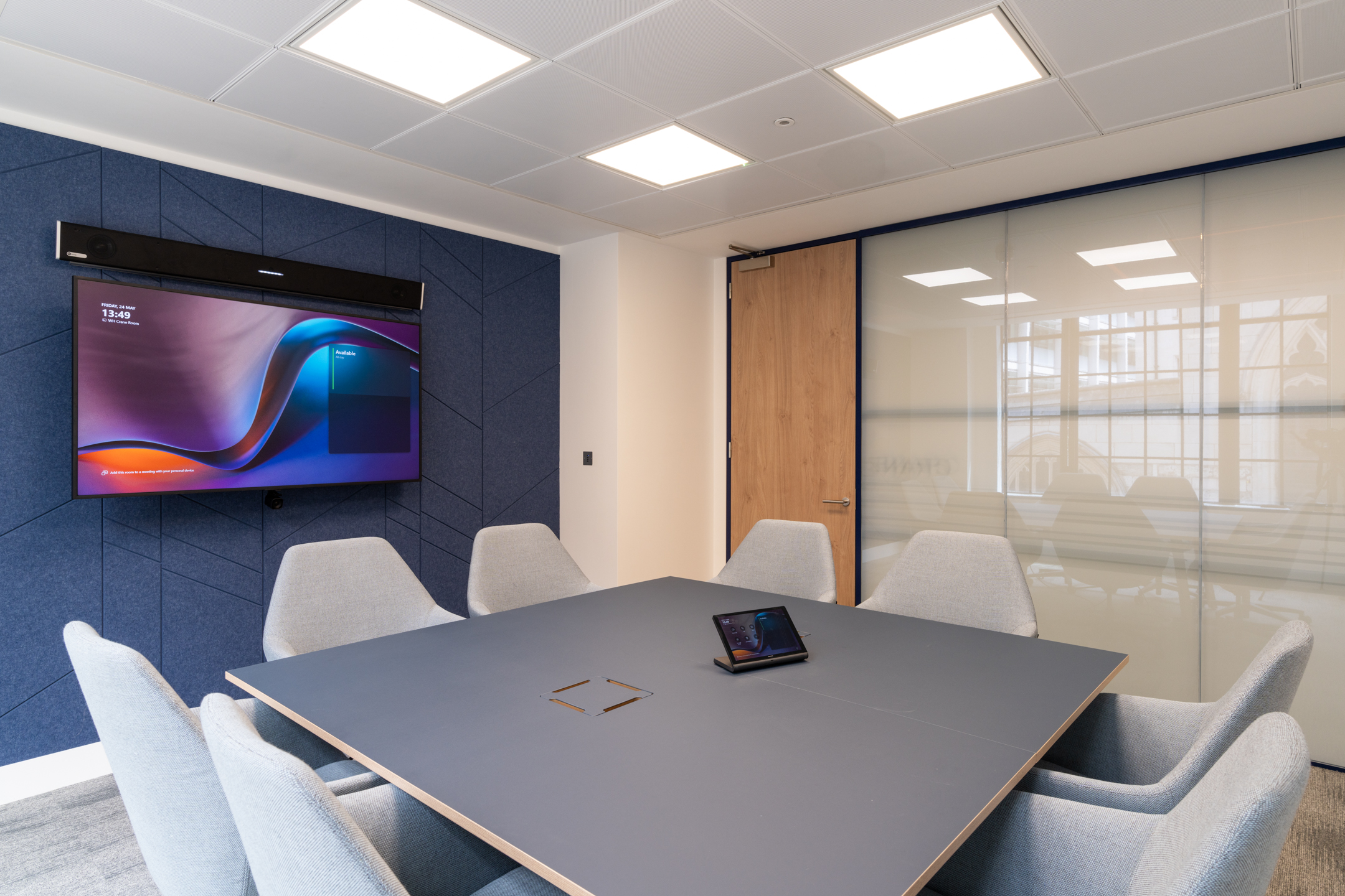 Modern meeting room at the Port of London Authority office by Two, featuring a sleek table, integrated technology, and acoustic panelled walls.