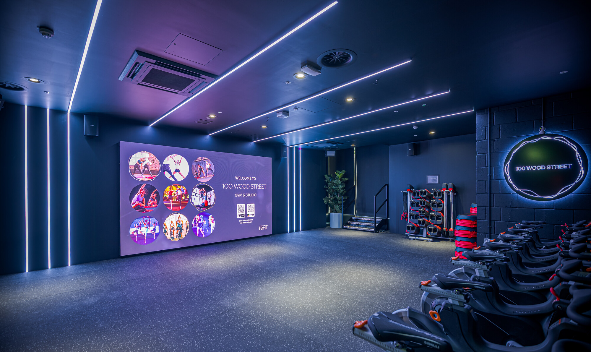 The ReFIT Gym's cutting-edge cycling studio at 100 Wood Street, designed by Two, features LED lighting and modern workout equipment.