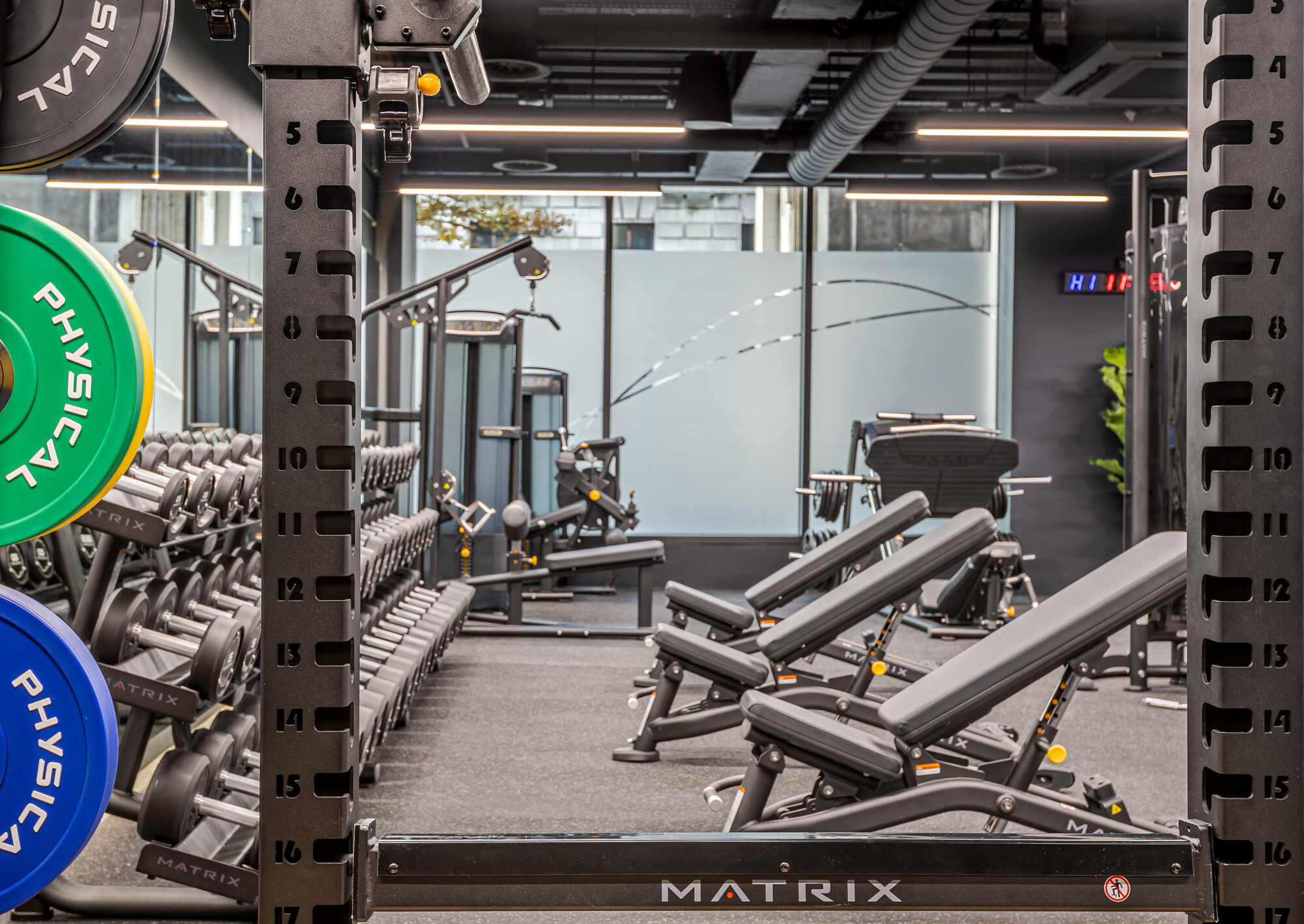 The ReFIT Gym at 100 Wood Street, designed by Two, features professional weightlifting equipment and benches within a well-lit, modern setting.