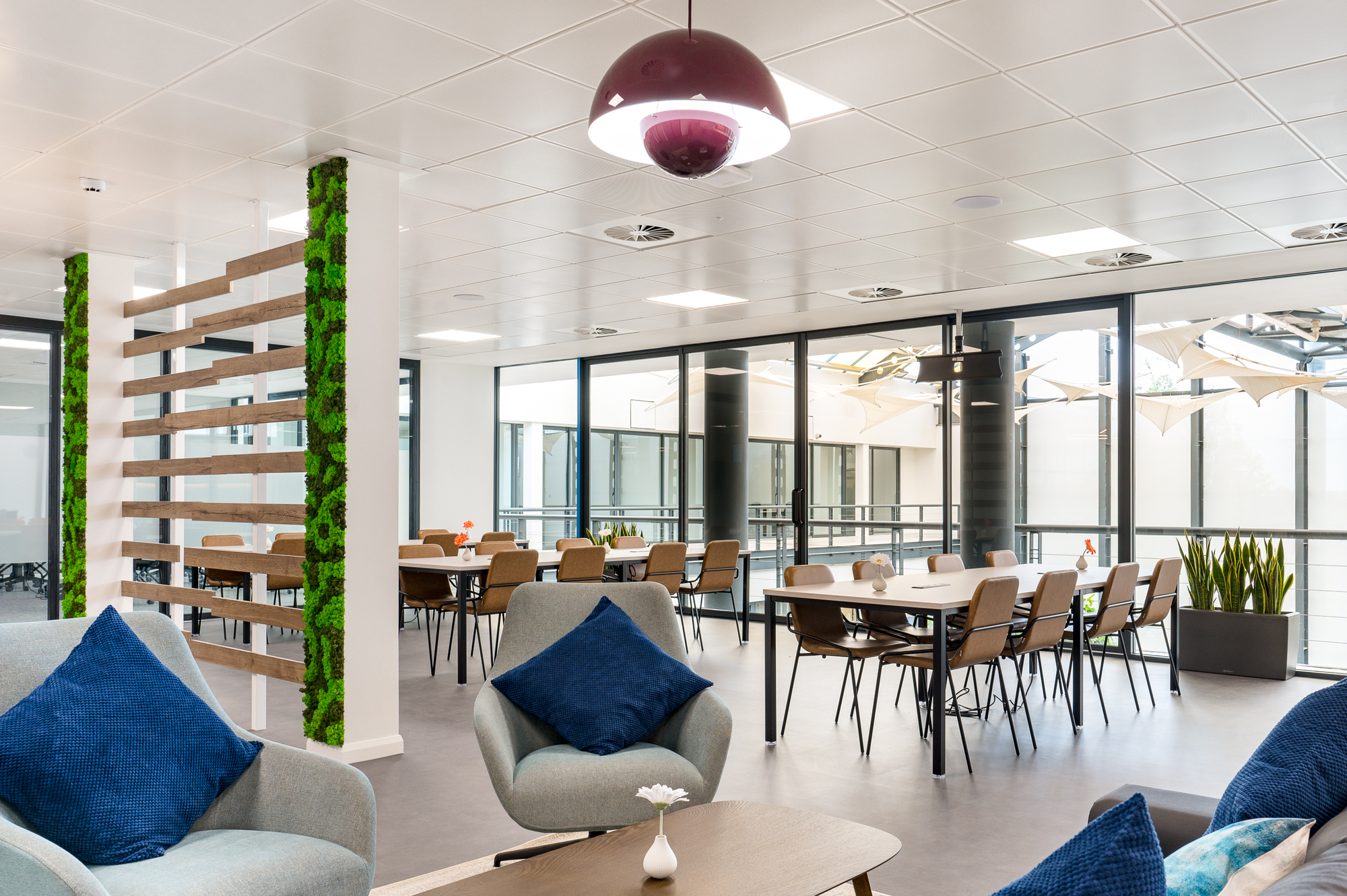 Lounge seating and dining area separated by a wooden feature with greenery, designed by Two for Serendipity Labs in Bristol.