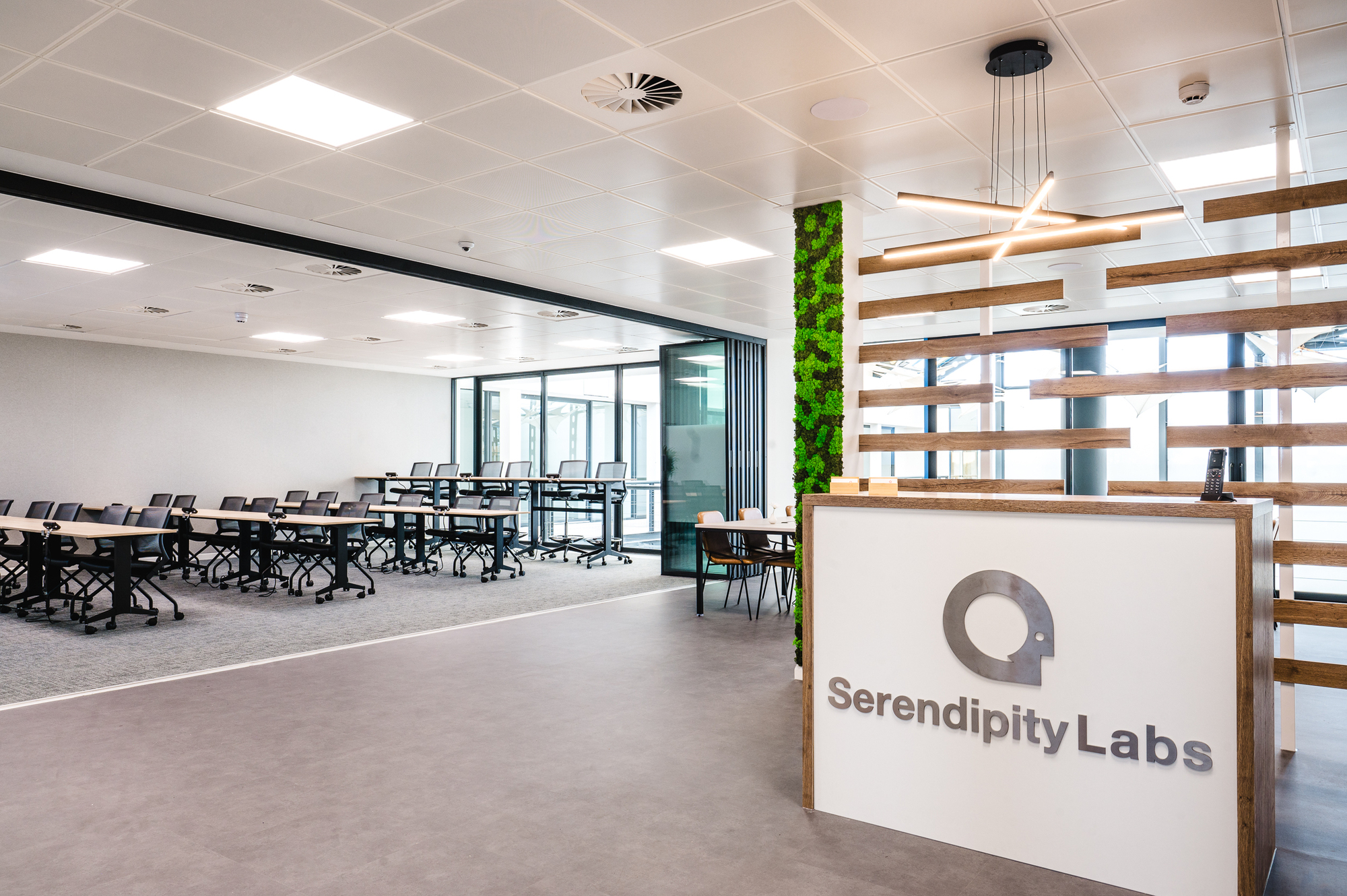 Serendipity Labs reception area with a folding wall opening into the adjacent training room, showcasing versatile workspace design by Two.