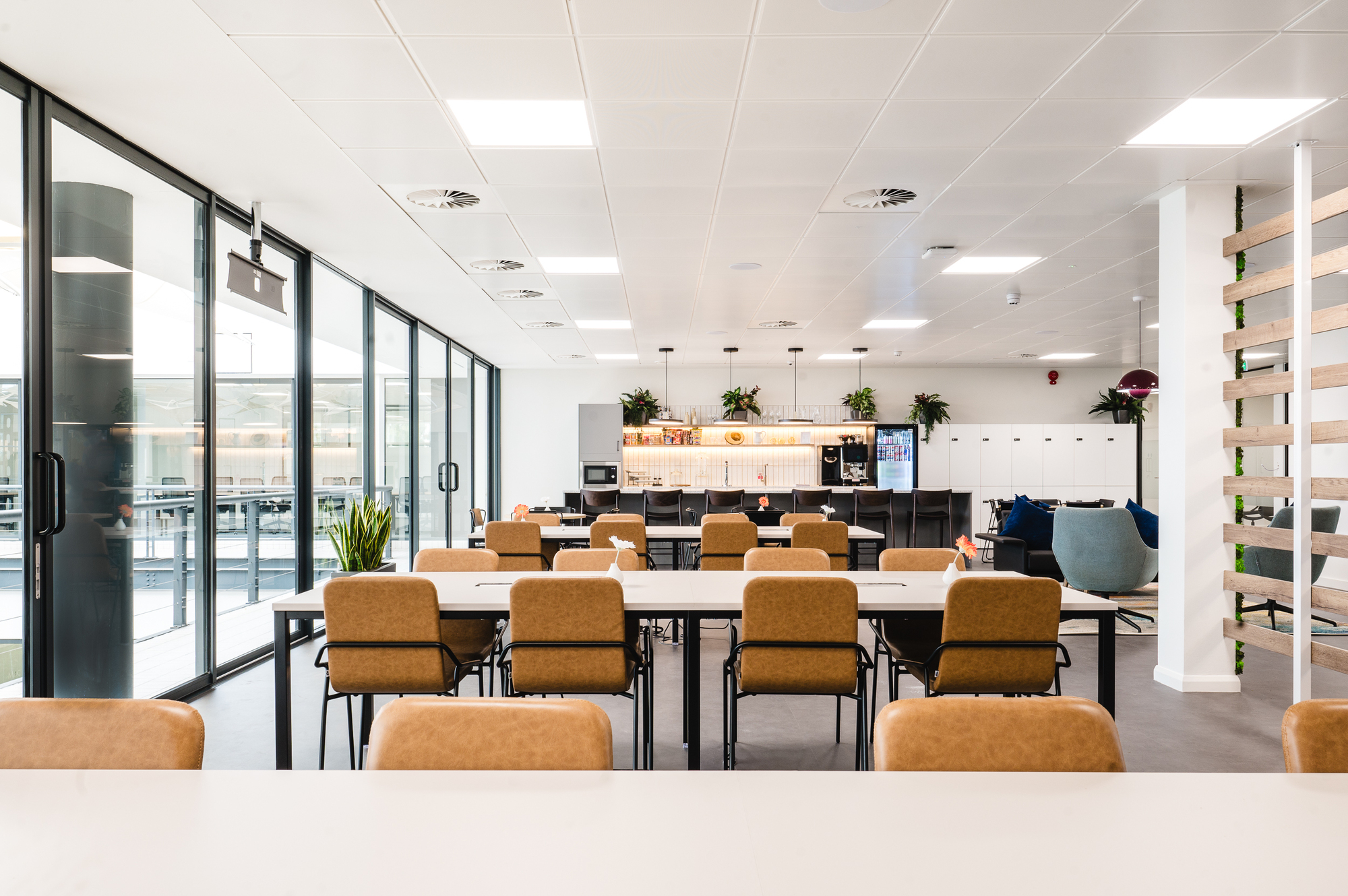 Spacious coworking area at Serendipity Labs, combining collaborative workstations with a modern kitchen and lounge space.