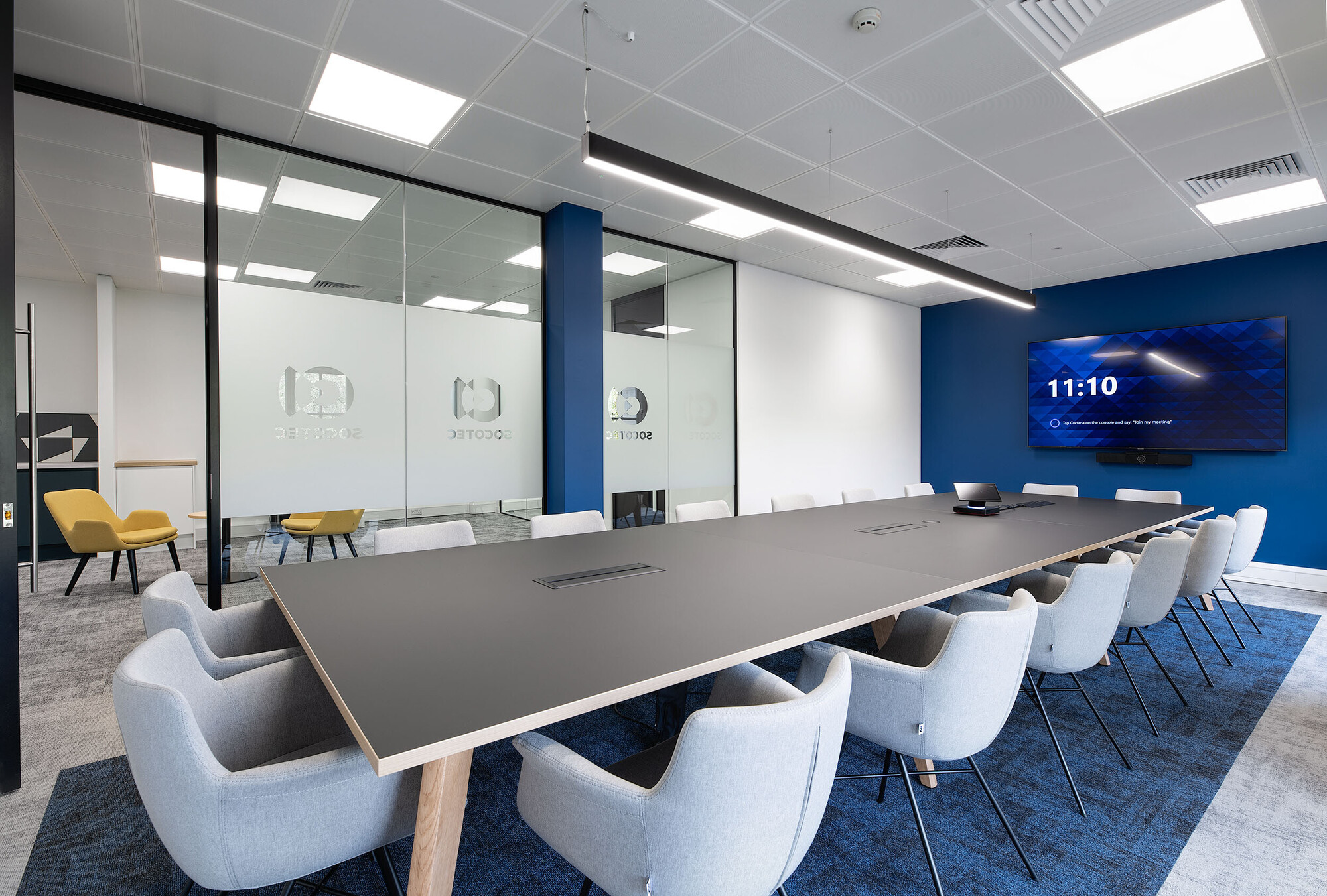 16 seated meeting room at Socotec with bespoke frosted glass divisons and a screen