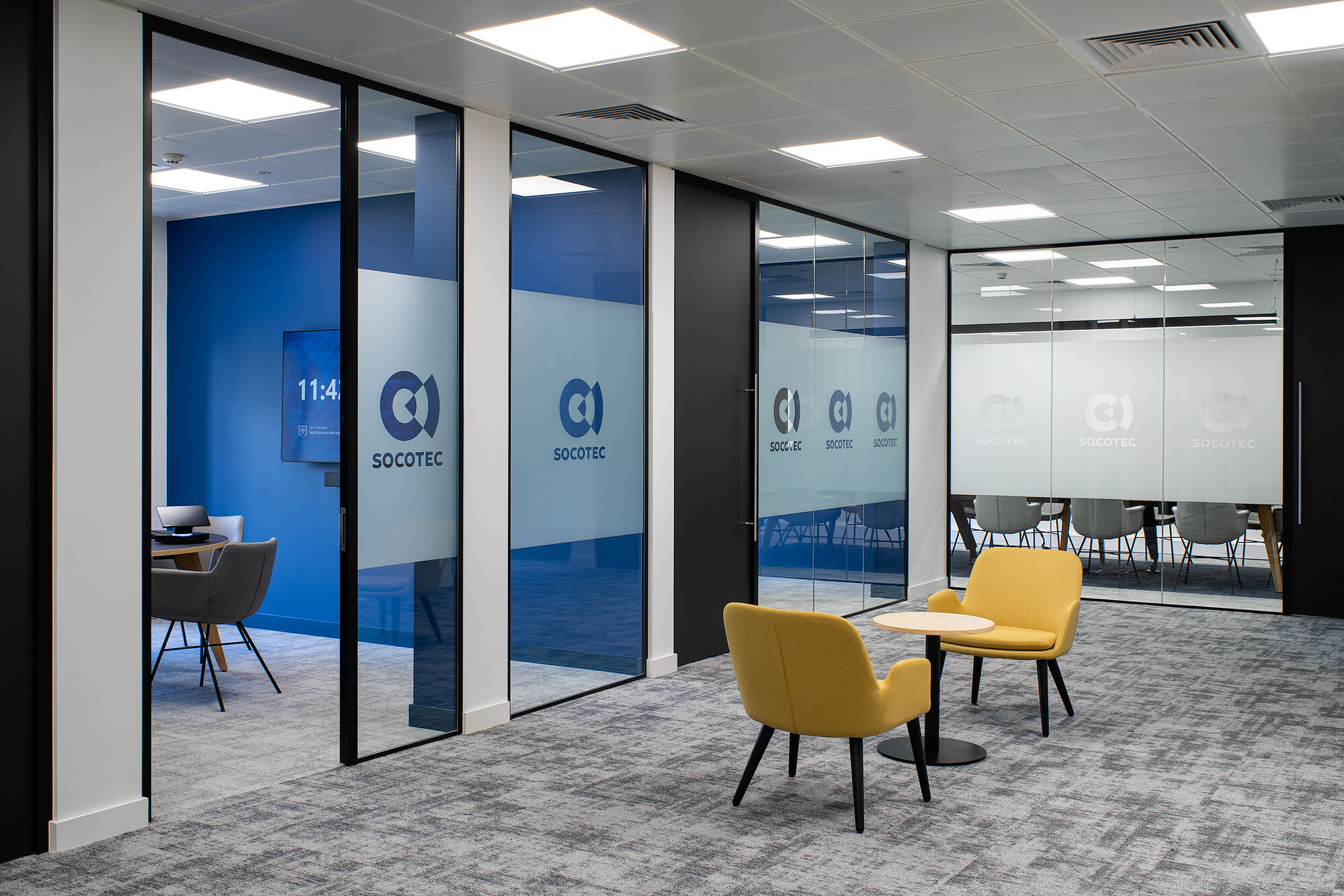 Overview of meeting rooms with a small desk and chairs central to the room.