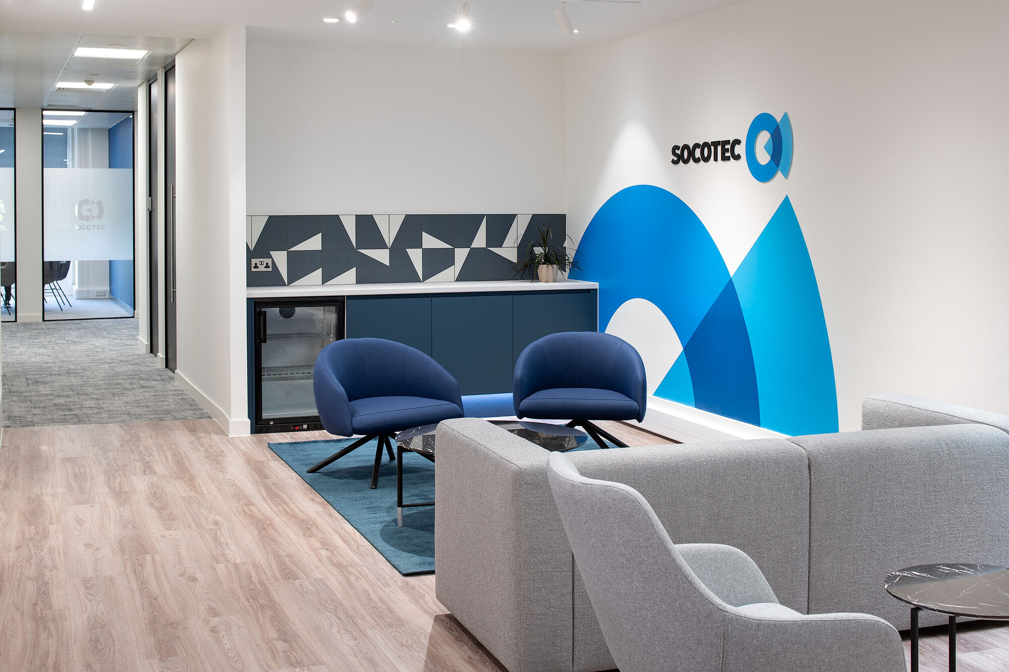 Socotec bespoke wall branding with blues, greys and whites decorating the space