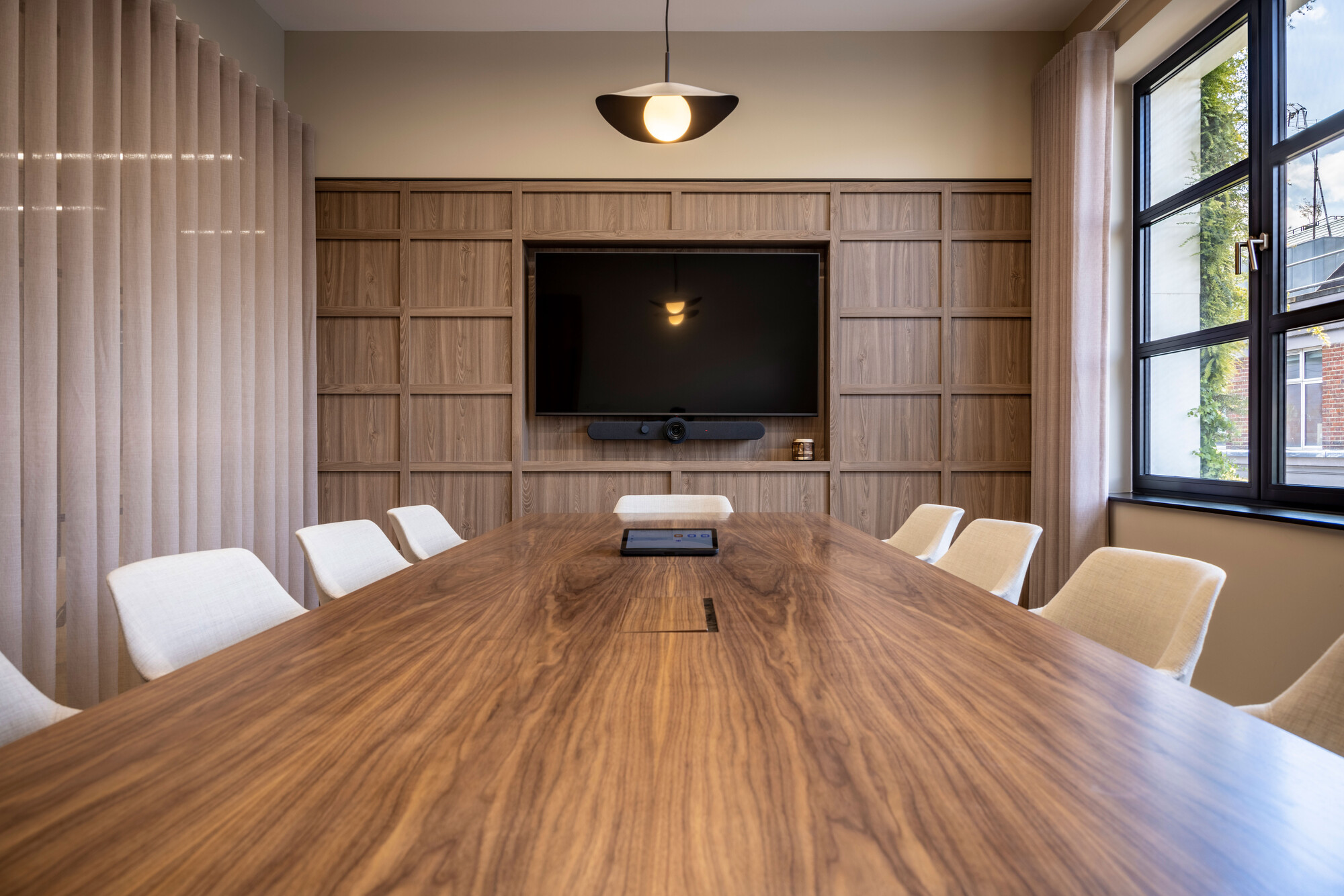 Transition's meeting space with a timber table and integrated AV wall, designed by Two to reflect sustainability and elegance.