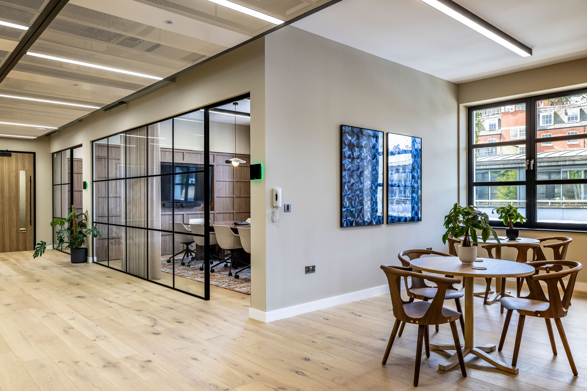 Open-plan workspace at Transition's London office by Two, combining glass partitions with natural wood finishes for a modern and sustainable design.