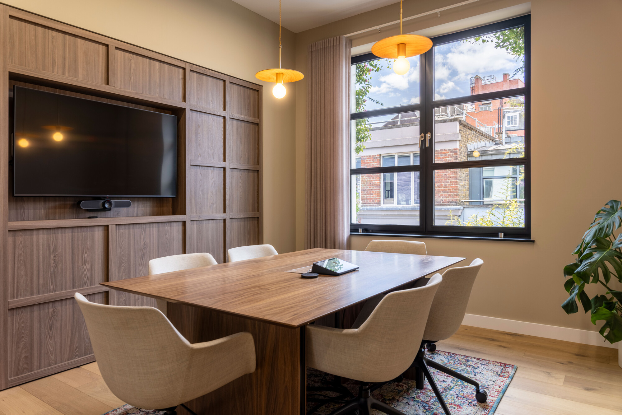 Transition's meeting room designed by Two, featuring a wood-panelled wall and a large window for natural light.