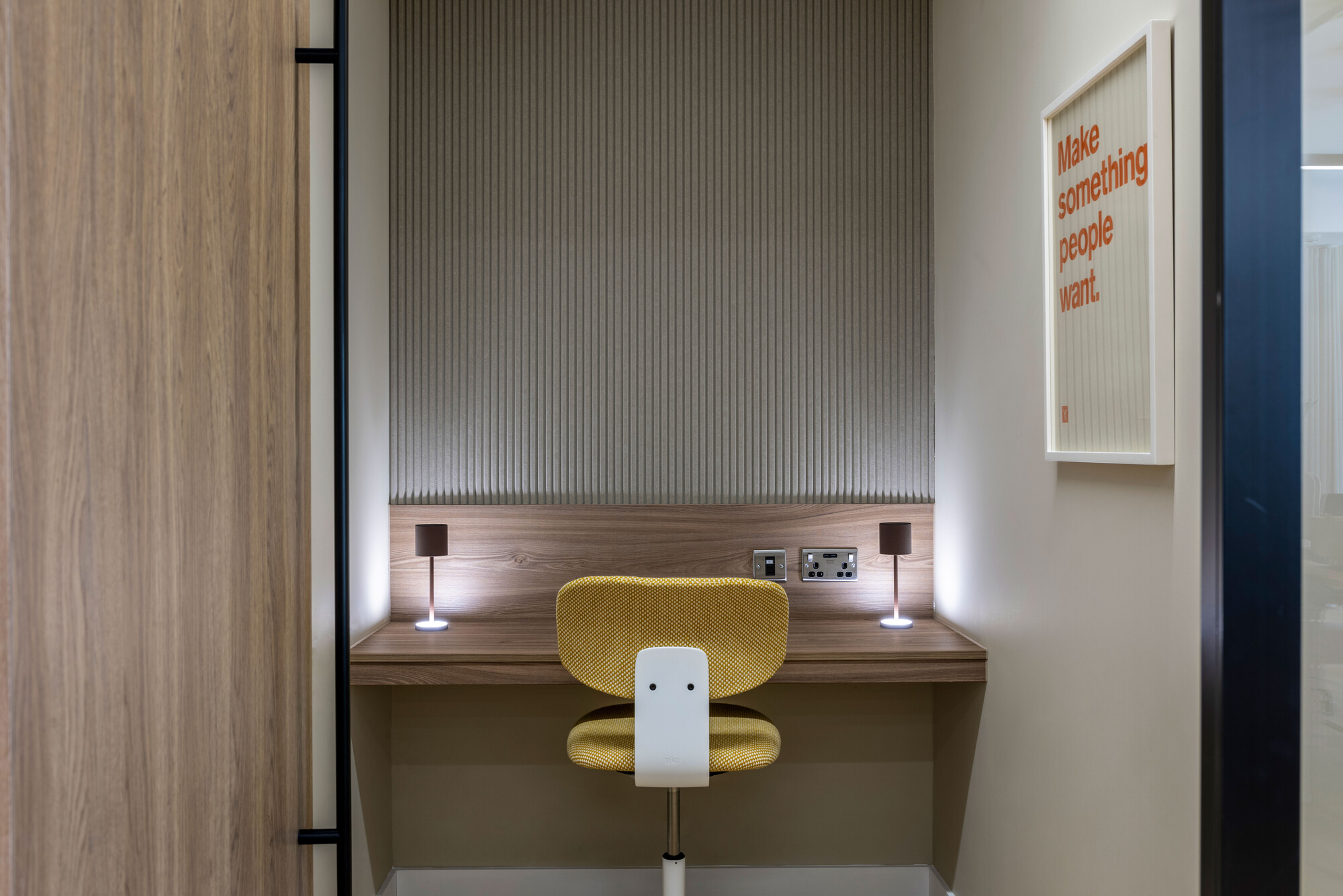 The zoom room at Transition has a wooden desk and a yellow chair for a functional yet stylish setup.