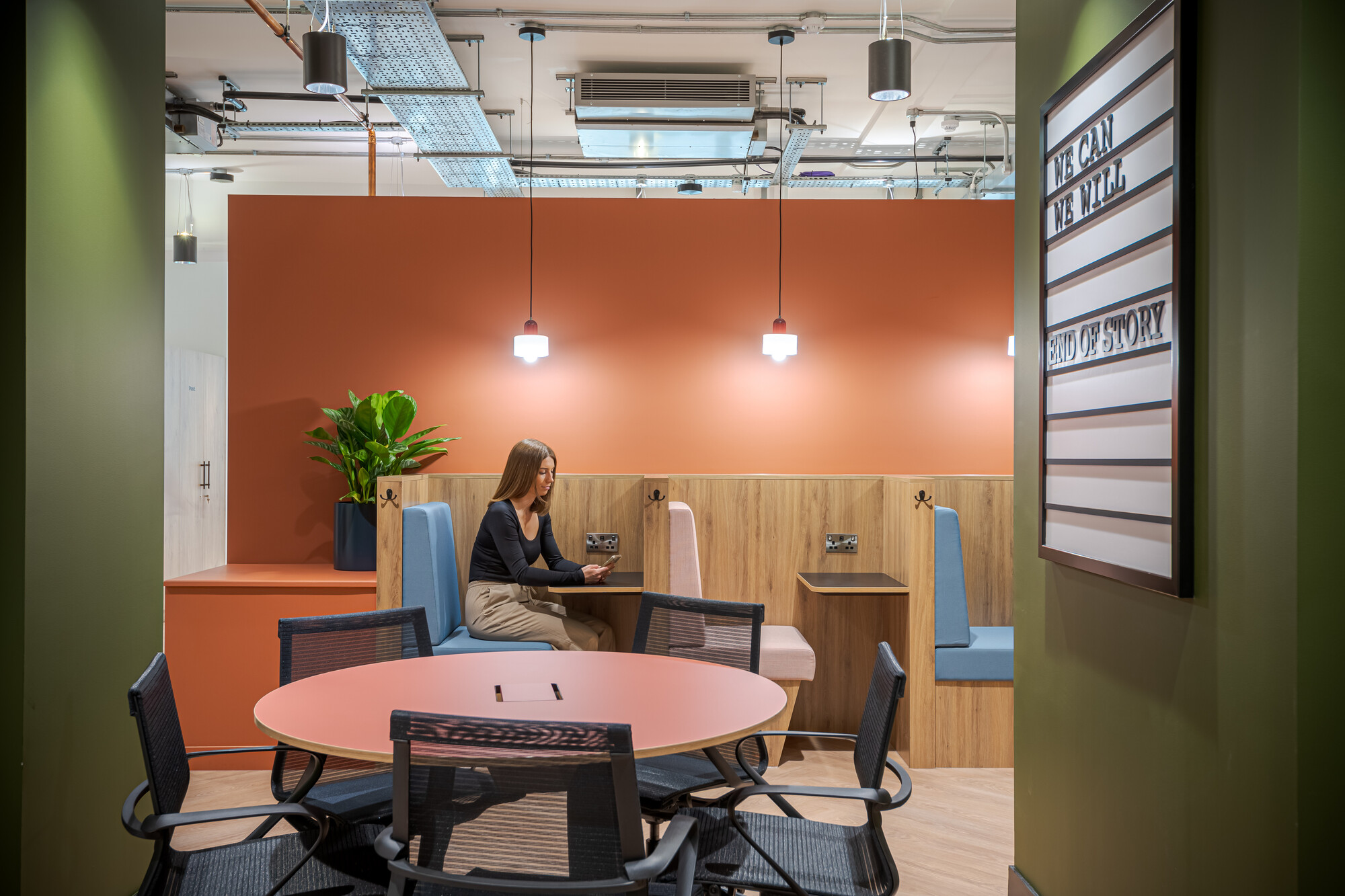 Warm-toned booth seating and a collaborative table at the Typewriter Building, thoughtfully designed by Two for Work.Life