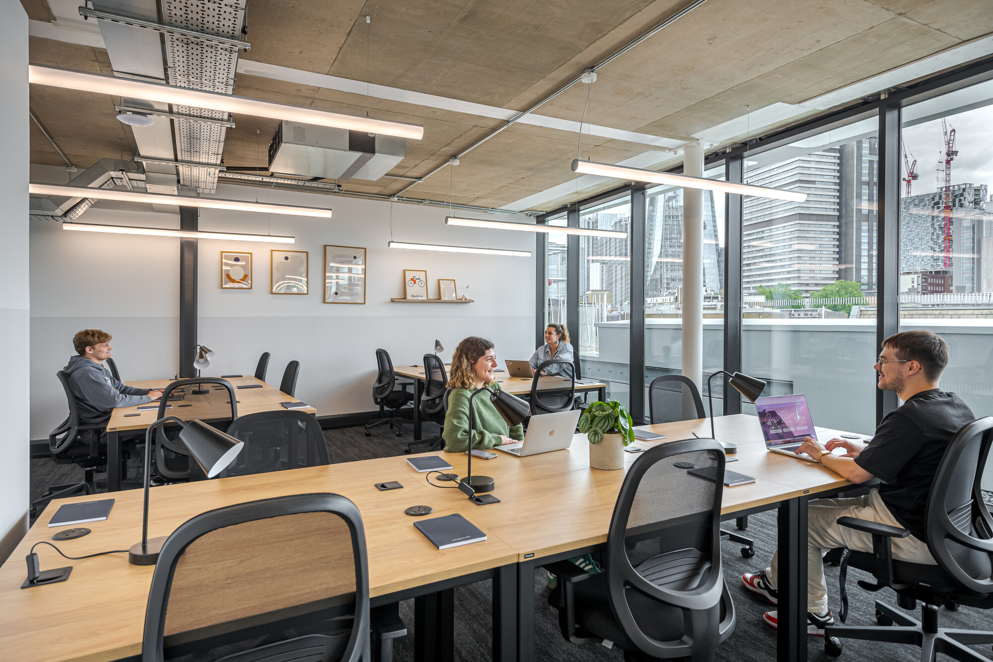 ork.Life at the Typewriter Building designed by Two, with an open-plan workspace featuring large desks, ergonomic chairs, industrial-style lighting, and floor-to-ceiling windows offering city views.