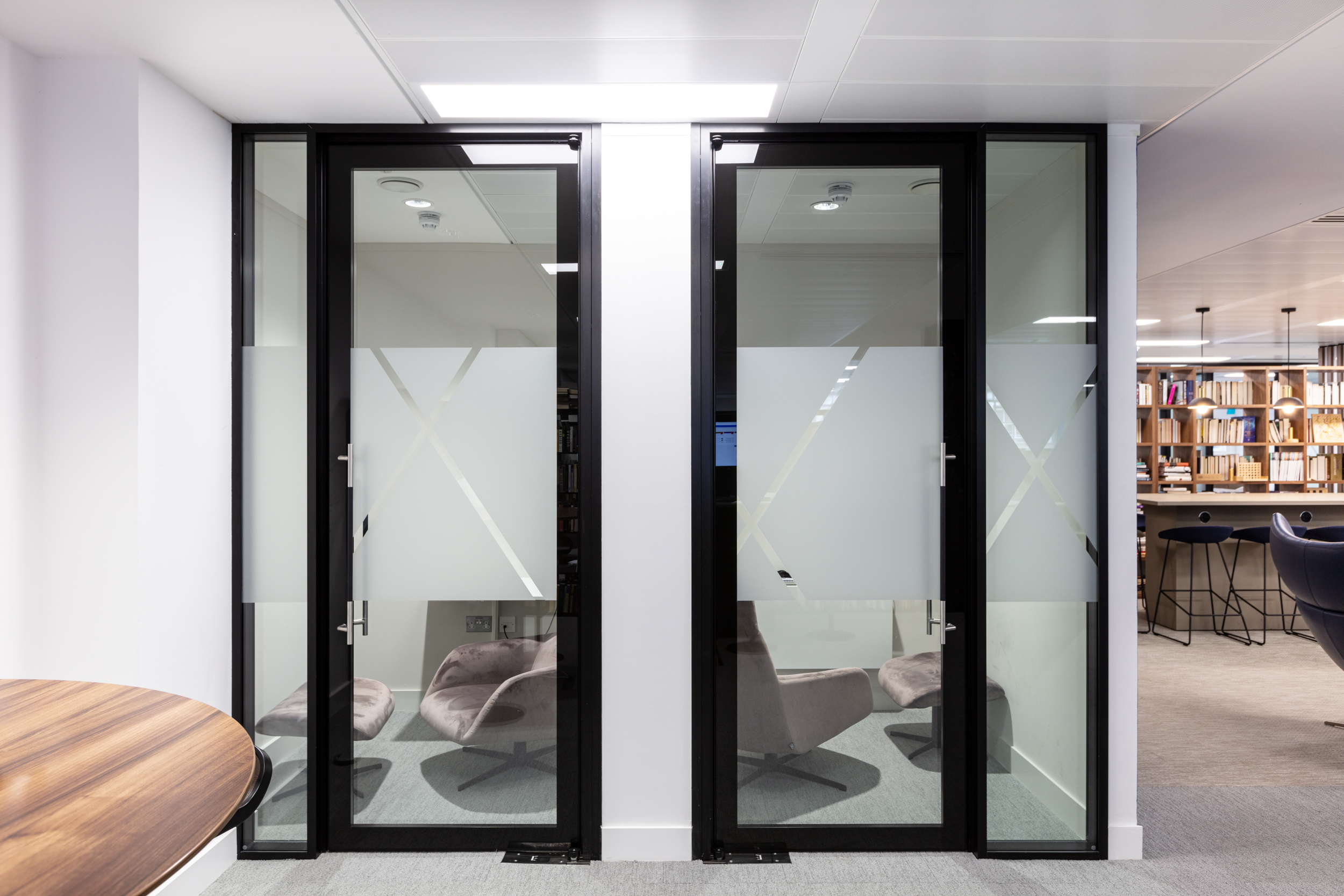 Private meeting rooms at Urban Exposure workspace by Two, designed with frosted glass doors and a modern aesthetic for focused collaboration.