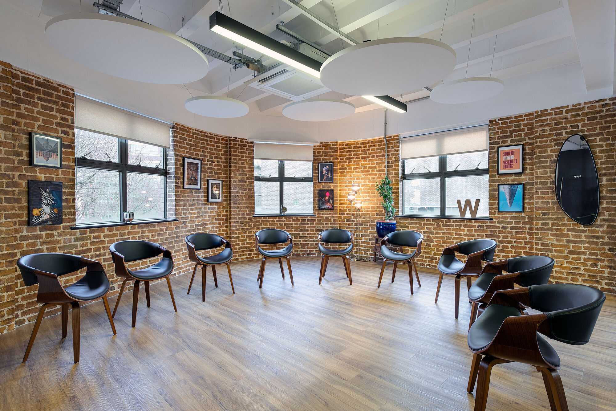 Wiser's multipurpose room with exposed brick walls, modern seating, and decorative accents, designed by Two.