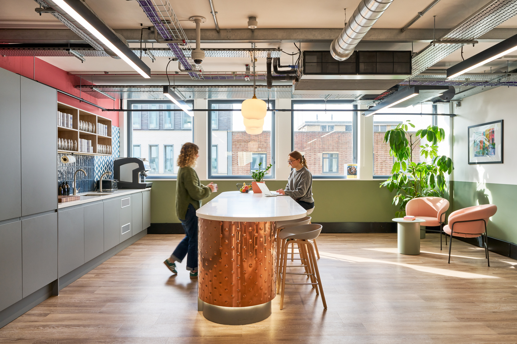 The teapoint at Work.Life Waverly House, designed by Two, with a copper island unit and bold green accents, blending style and functionality.