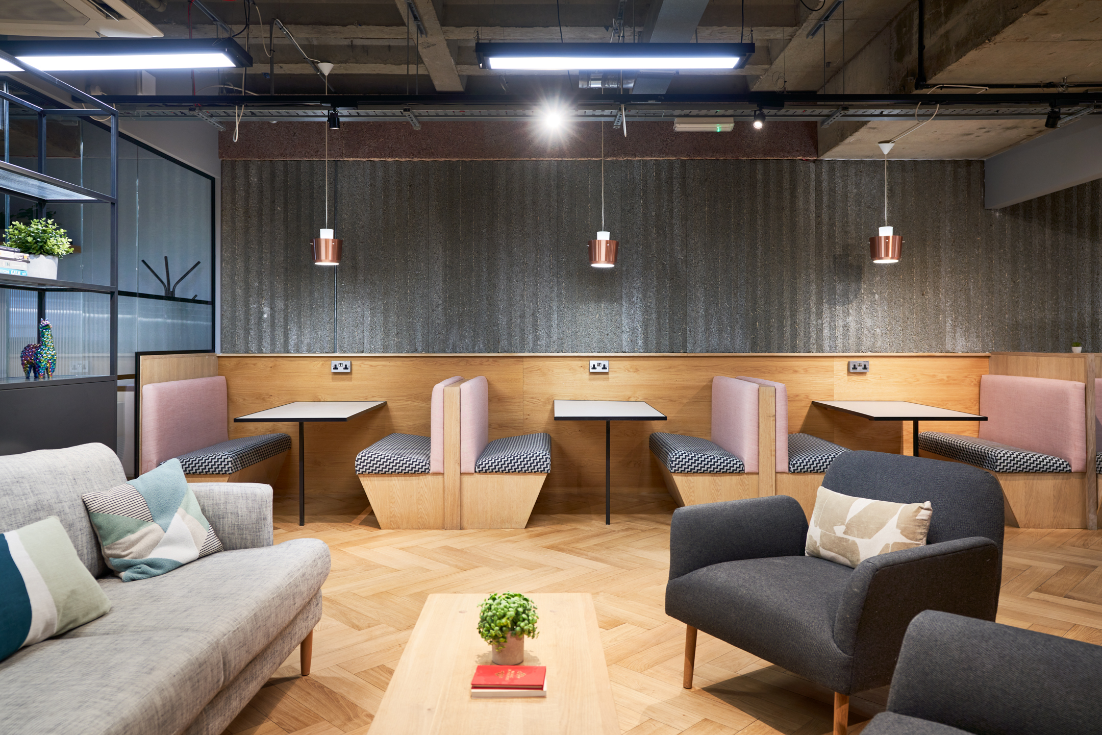 A relaxing breakout space at Work.life Liverpool Street, thoughtfully designed by Two, with pastel seating, booth areas, and copper pendant lighting for a creative workspace atmosphere.