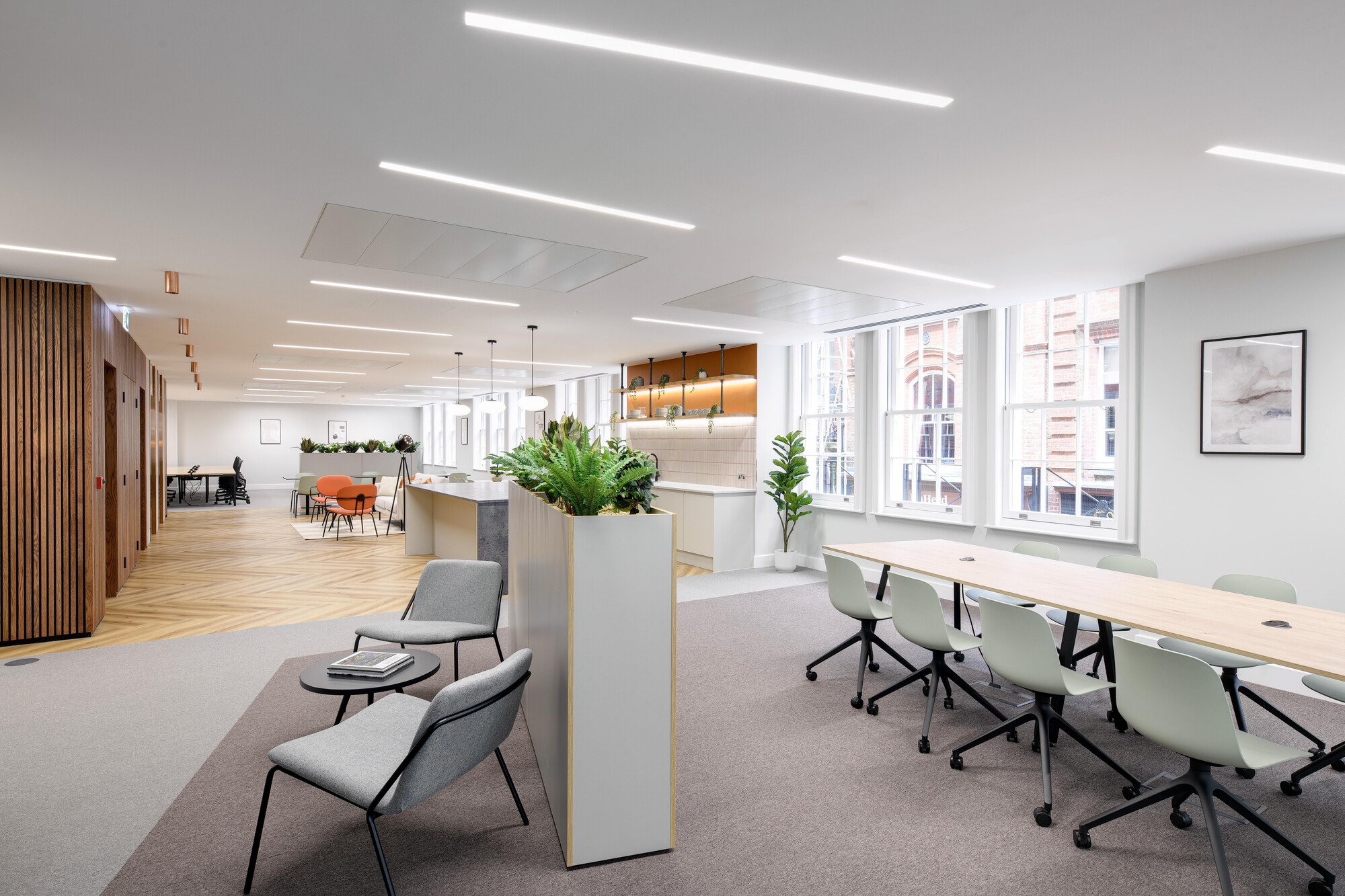 Contemporary Tenant-Ready™ office design by Two, featuring a collaborative layout with planter dividers, herringbone flooring, and vibrant accents.