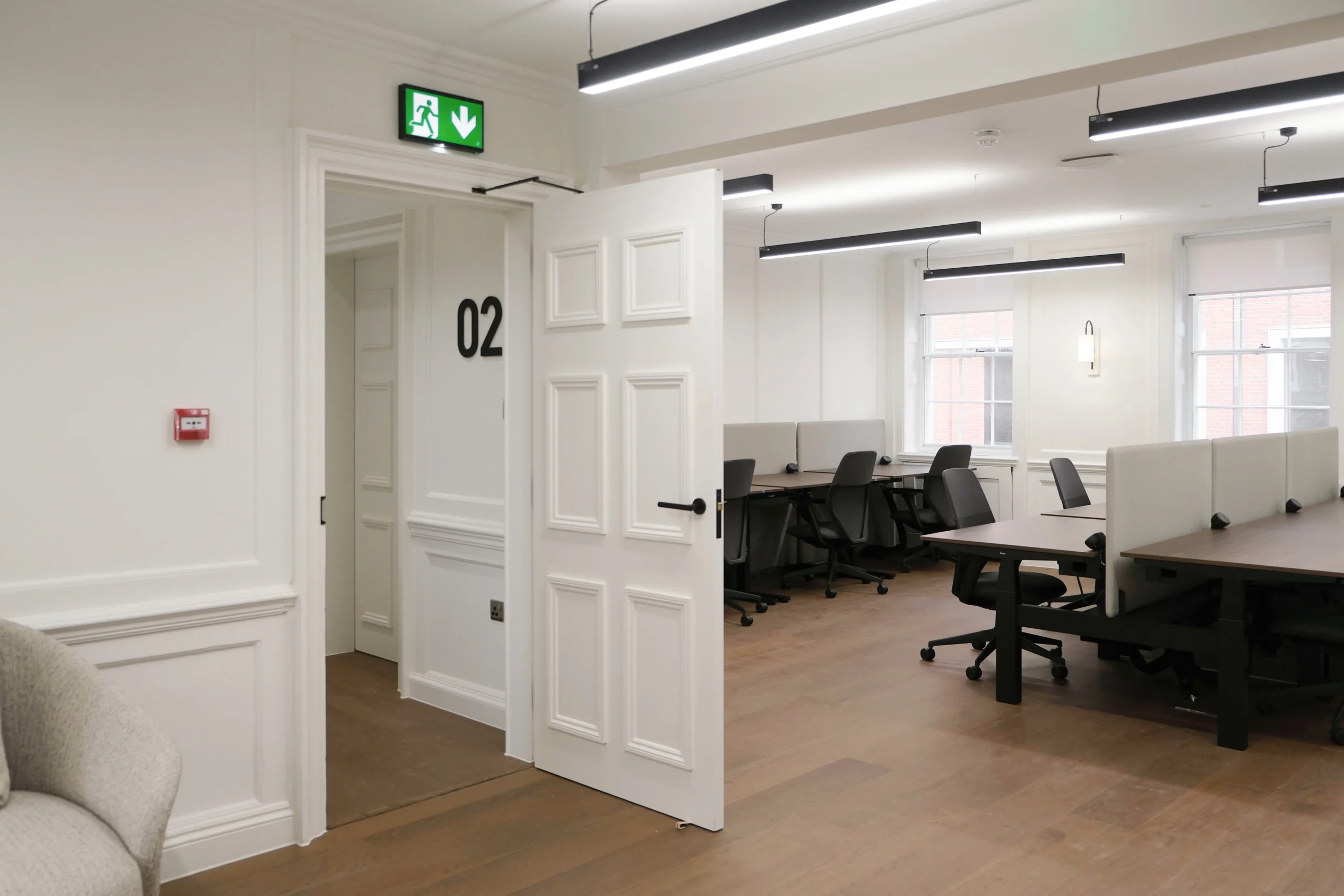 33 Mayfair office featuring back office chairs, and desking with white walls and black accents.