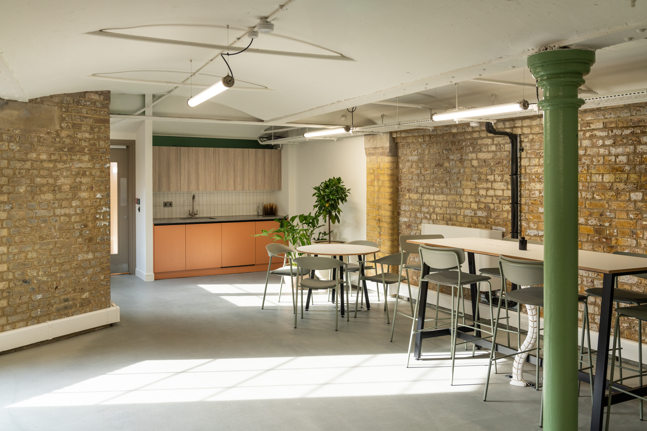 The Varnish Works first floor teapoint, featuring exposed bricks, open space through lighting and highstool tables