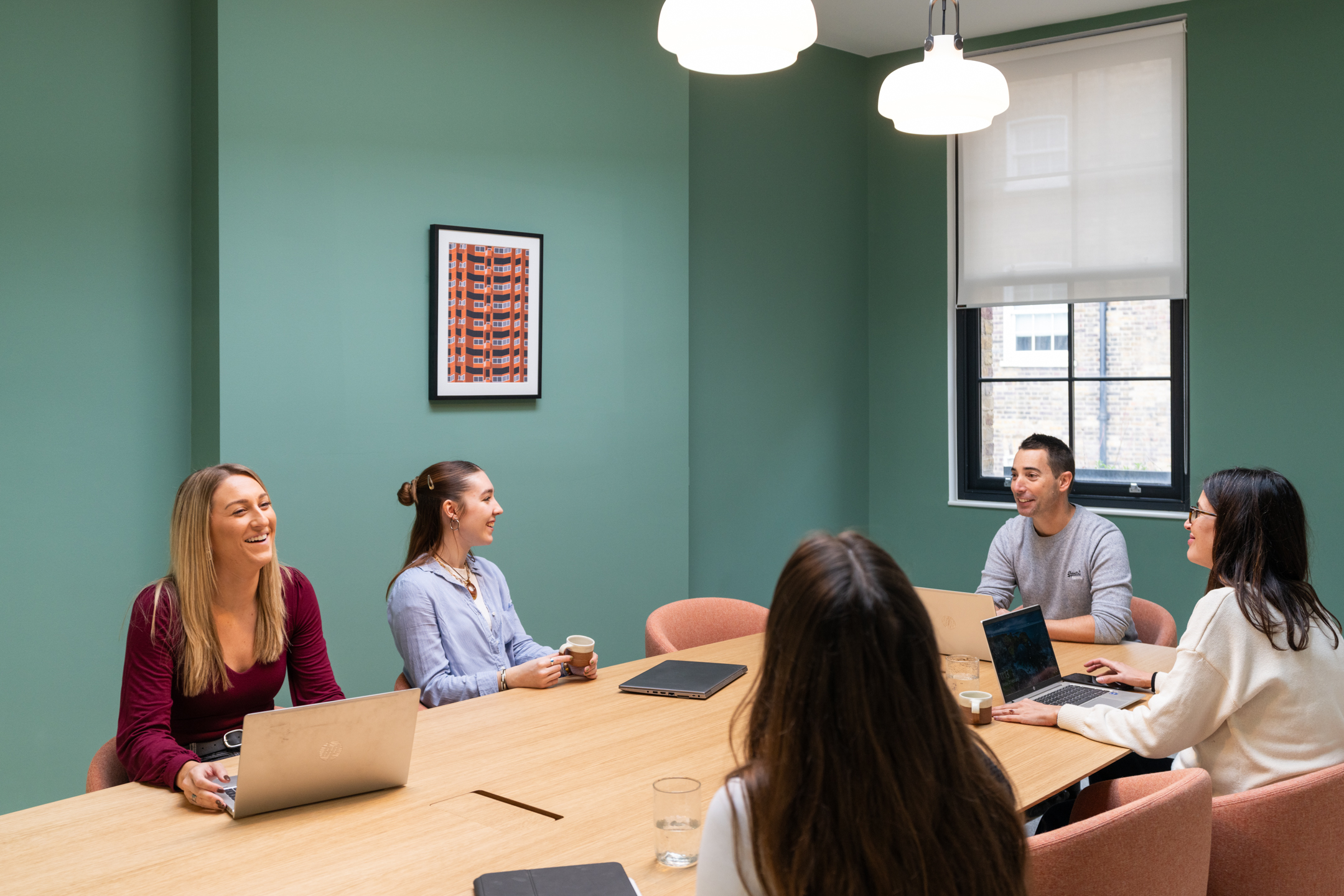 Employees at Two have a meeting at The Varnish Work's meeting room, the space is open and airy.