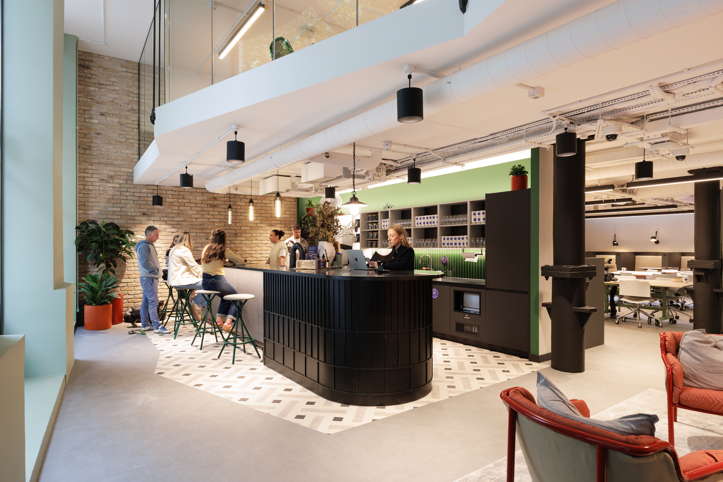 Ground floor bar area at Work.Life Clerkenwell Green with green tiled splashback, patterned flooring and people working, completed by Two.