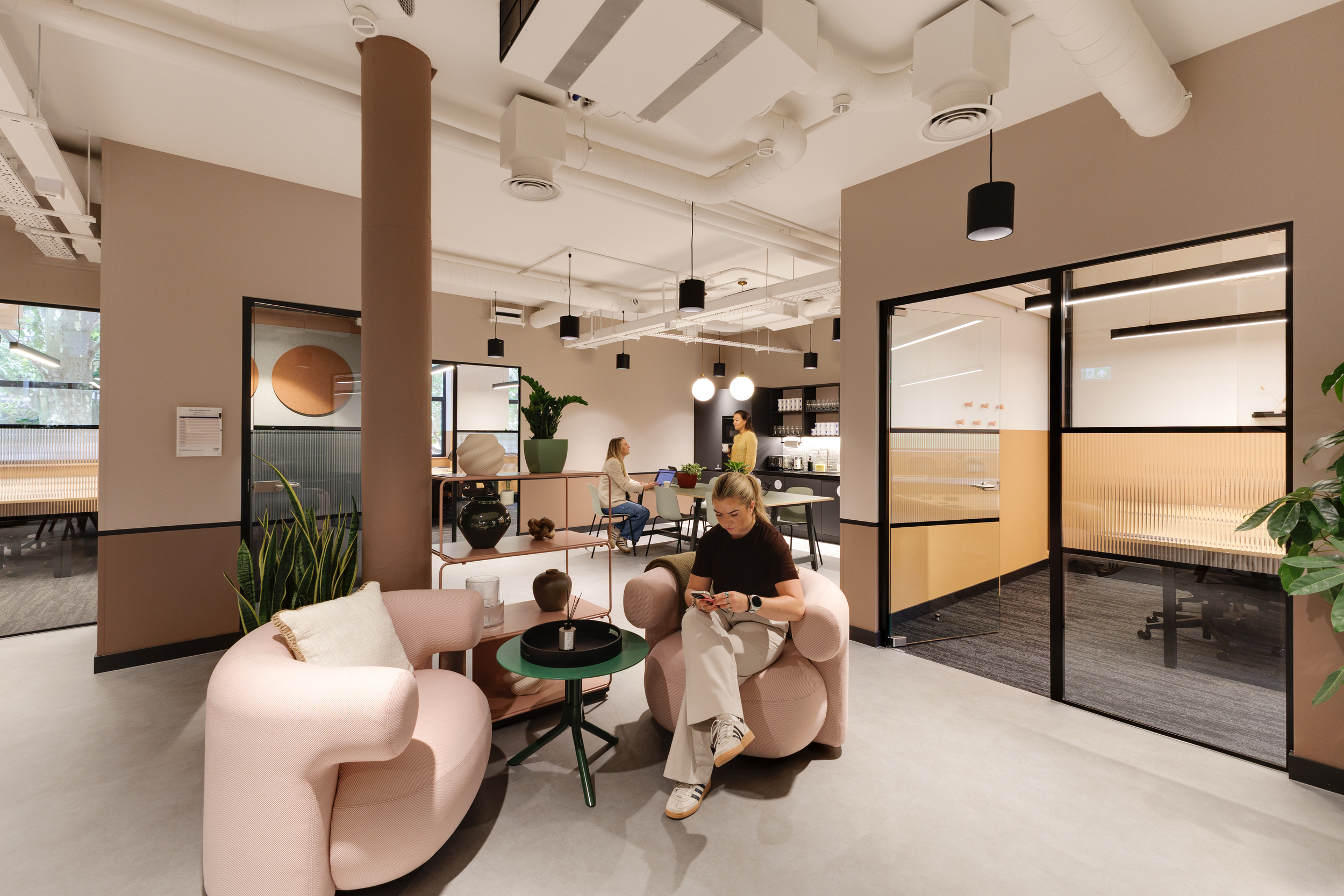 Lounge area at Work.Life Clerkenwell Green with blush seating, open shelving and soft lighting, captured during use by members, fitted out by Two.