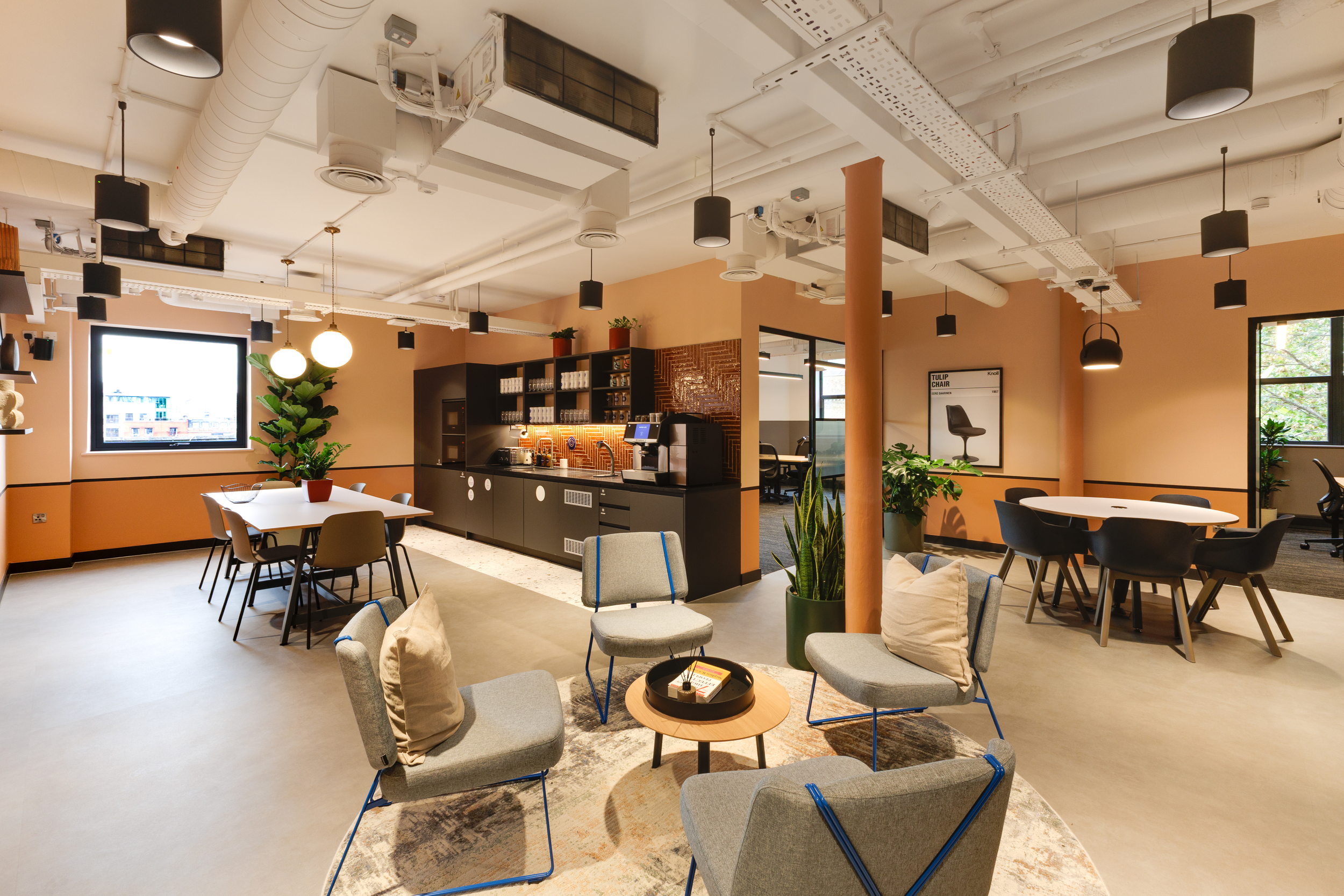 Bright communal space at Work.Life Clerkenwell Green with terracotta walls, open kitchen and lounge seating, completed by Two.